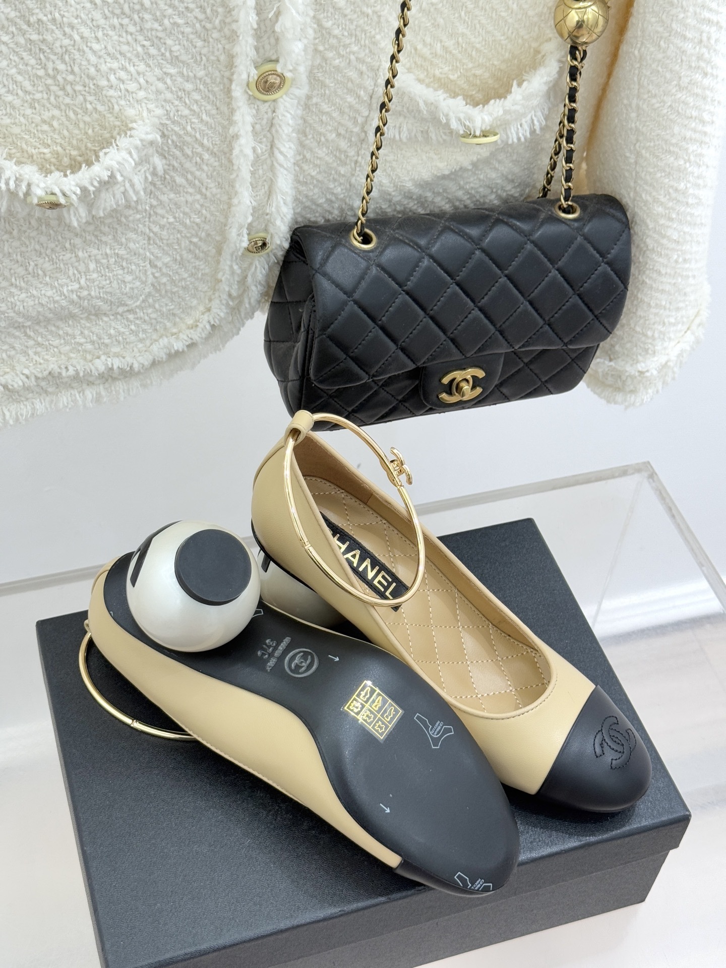 Luxury beige and black two-tone pumps with a unique large pearl heel and gold ankle hoop strap featuring a camellia flower. - Hình 9
