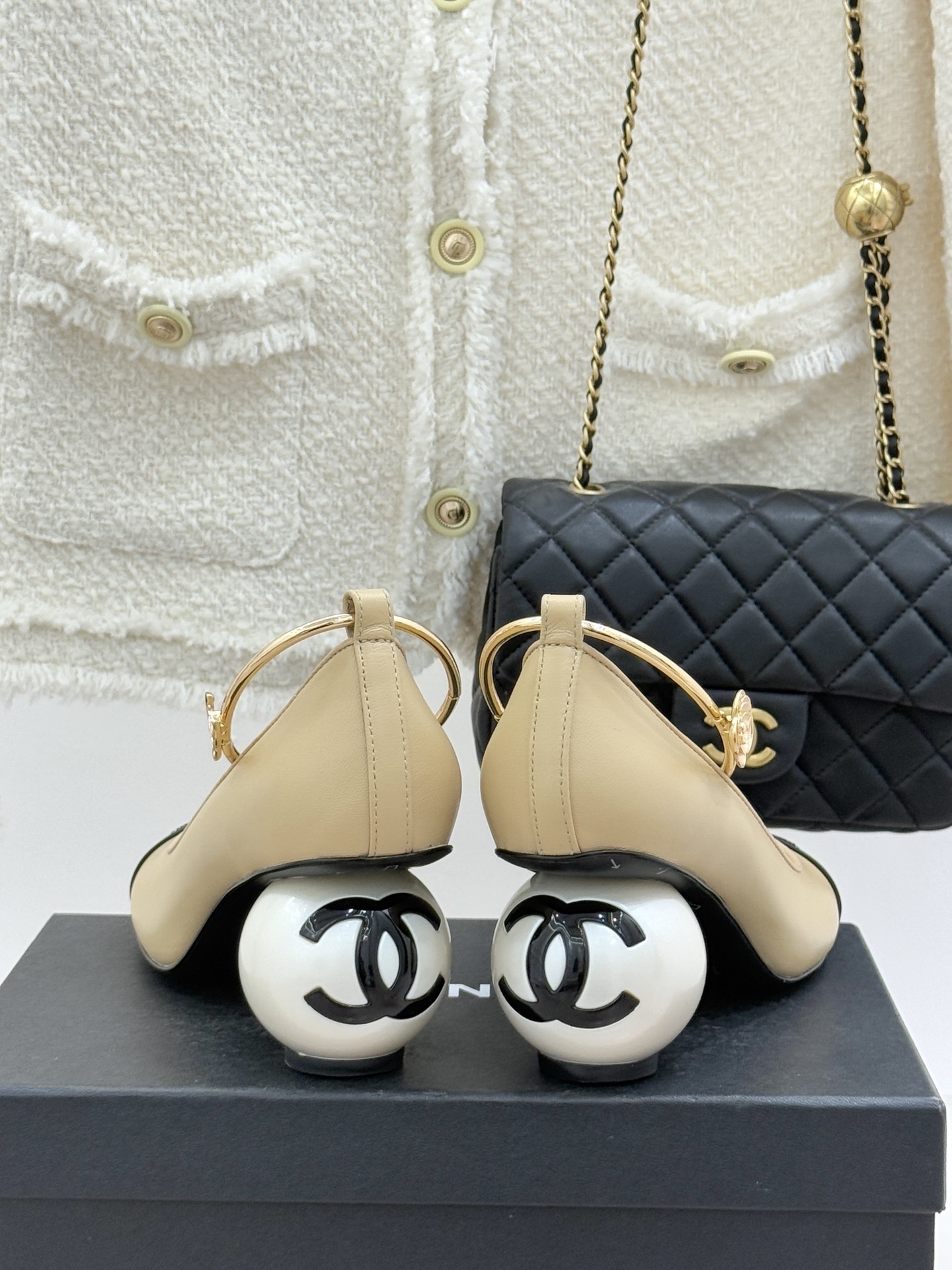 Luxury beige and black two-tone pumps with a unique large pearl heel and gold ankle hoop strap featuring a camellia flower. - Hình 6