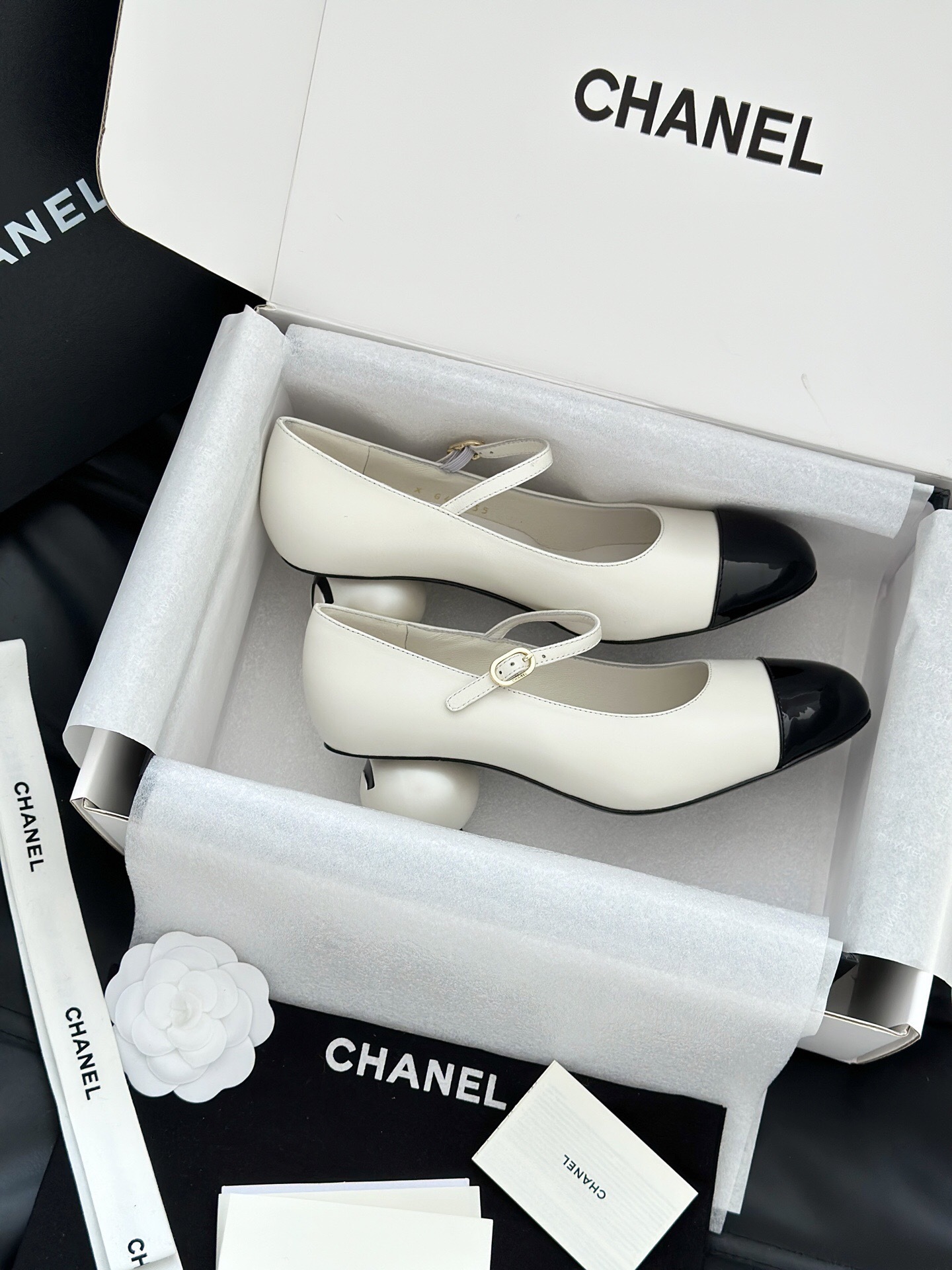 Luxury Chanel Mary Jane pumps in white leather with black patent leather cap toe and block heel, presented in a signature white box. - Hình 6