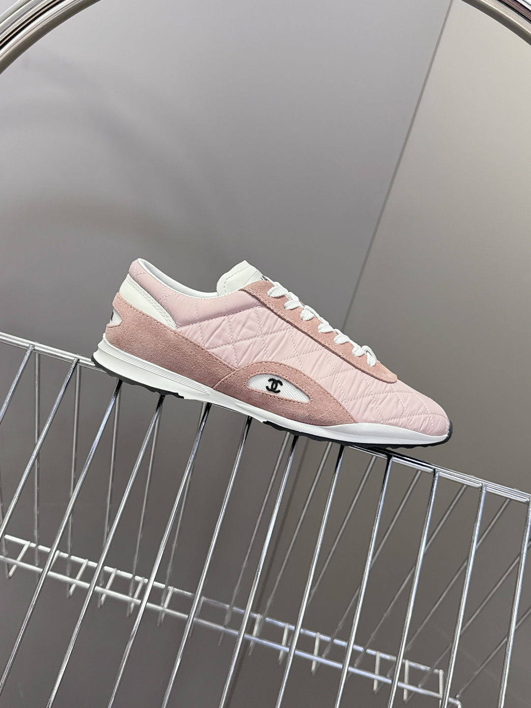 A pair of luxury Chanel pink quilted sneakers with suede trim and white laces placed next to a Chanel branded shoe box. - Hình 5