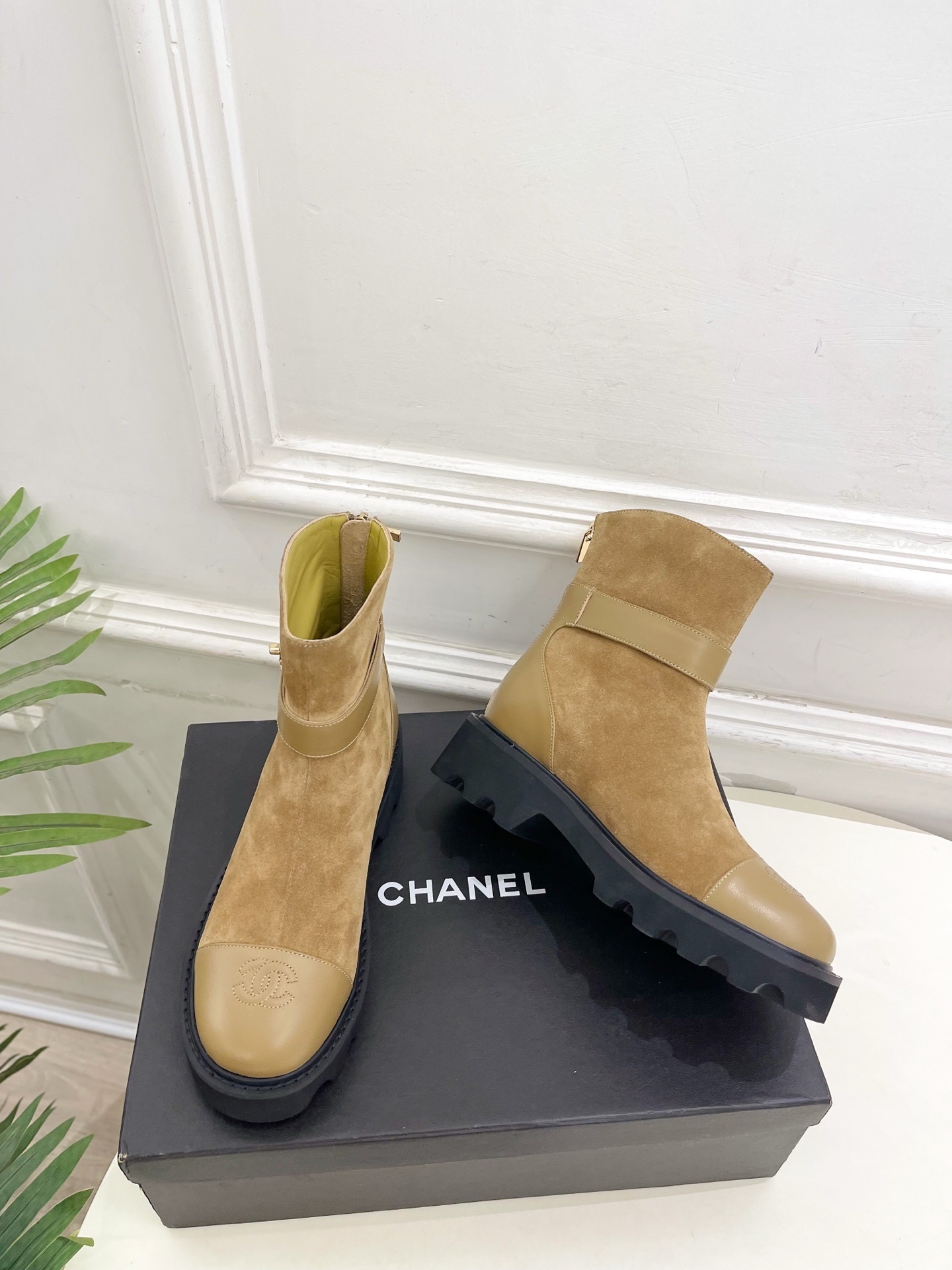 Luxury Chanel tan suede ankle boots with chunky black soles and gold CC buckle detail on a designer box. - Hình 5