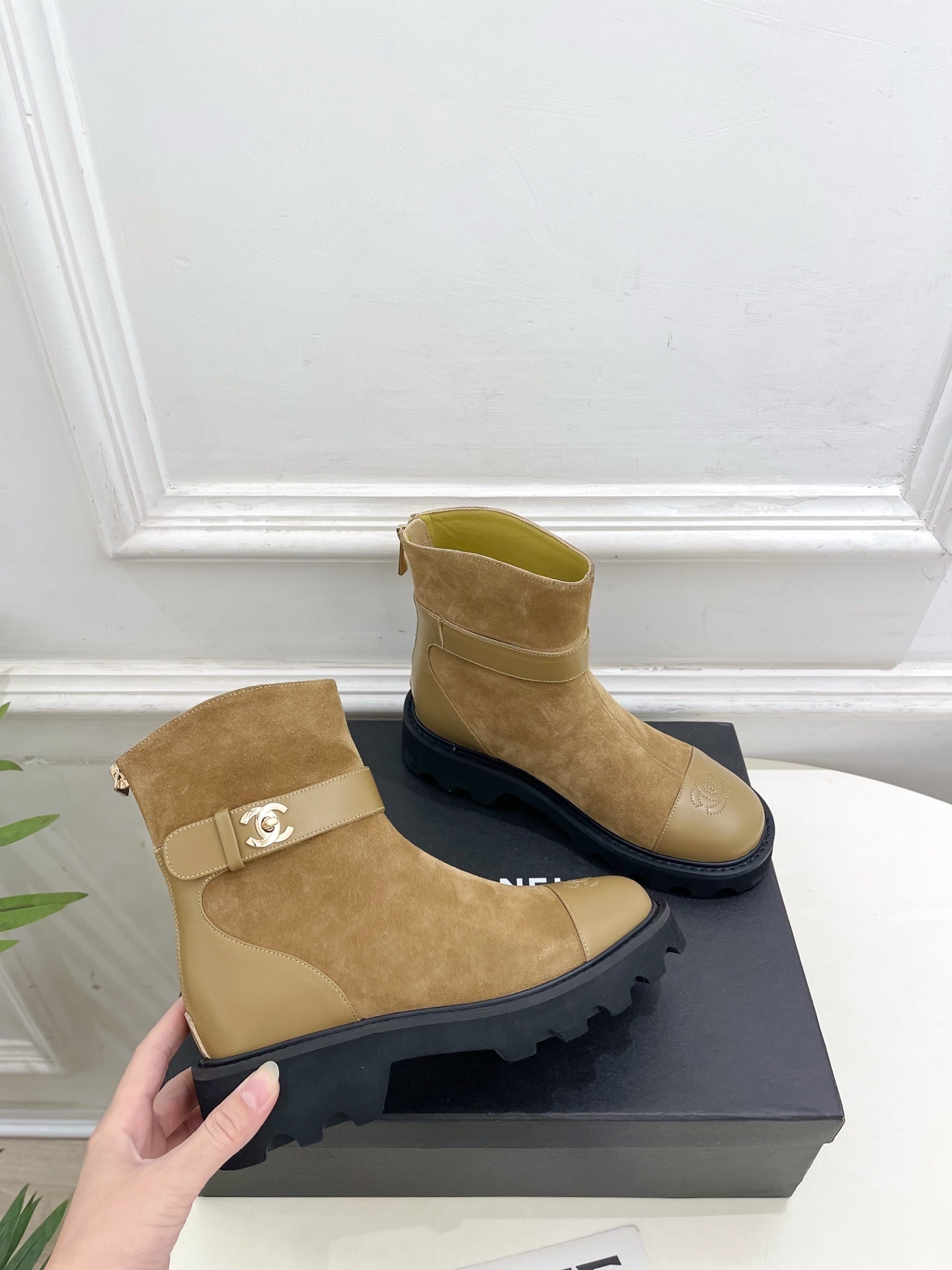 Luxury Chanel tan suede ankle boots with chunky black soles and gold CC buckle detail on a designer box. - Hình 4
