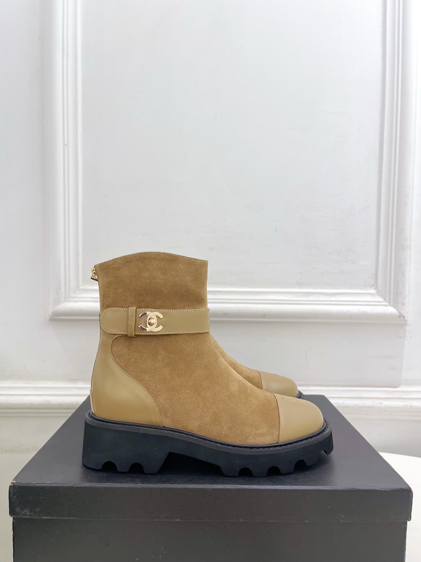 Luxury Chanel tan suede ankle boots with chunky black soles and gold CC buckle detail on a designer box. - Hình 2