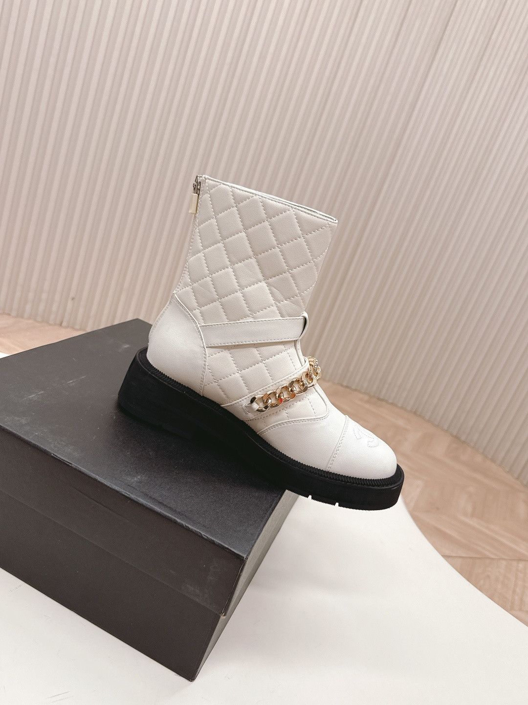 Luxury white quilted ankle boots with gold chain accents and a chunky black platform sole shown next to a designer box - Hình 9