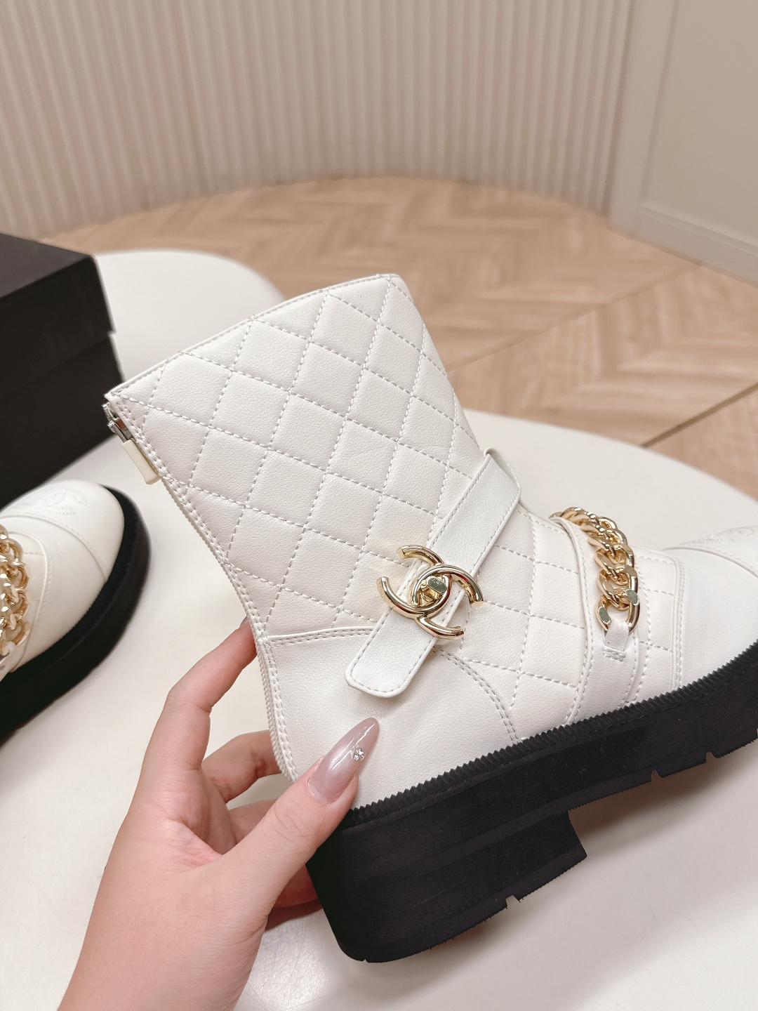 Luxury white quilted ankle boots with gold chain accents and a chunky black platform sole shown next to a designer box - Hình 4