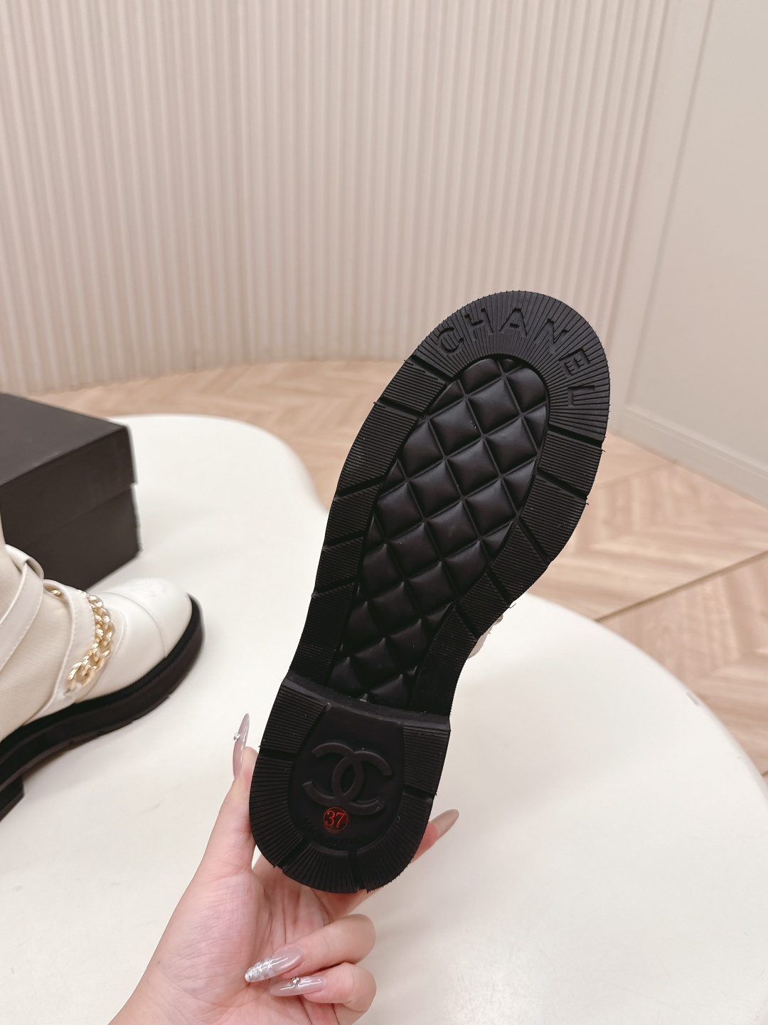 Pair of Chanel white leather sock ankle boots with gold chain and CC logo on a white table - Hình 9