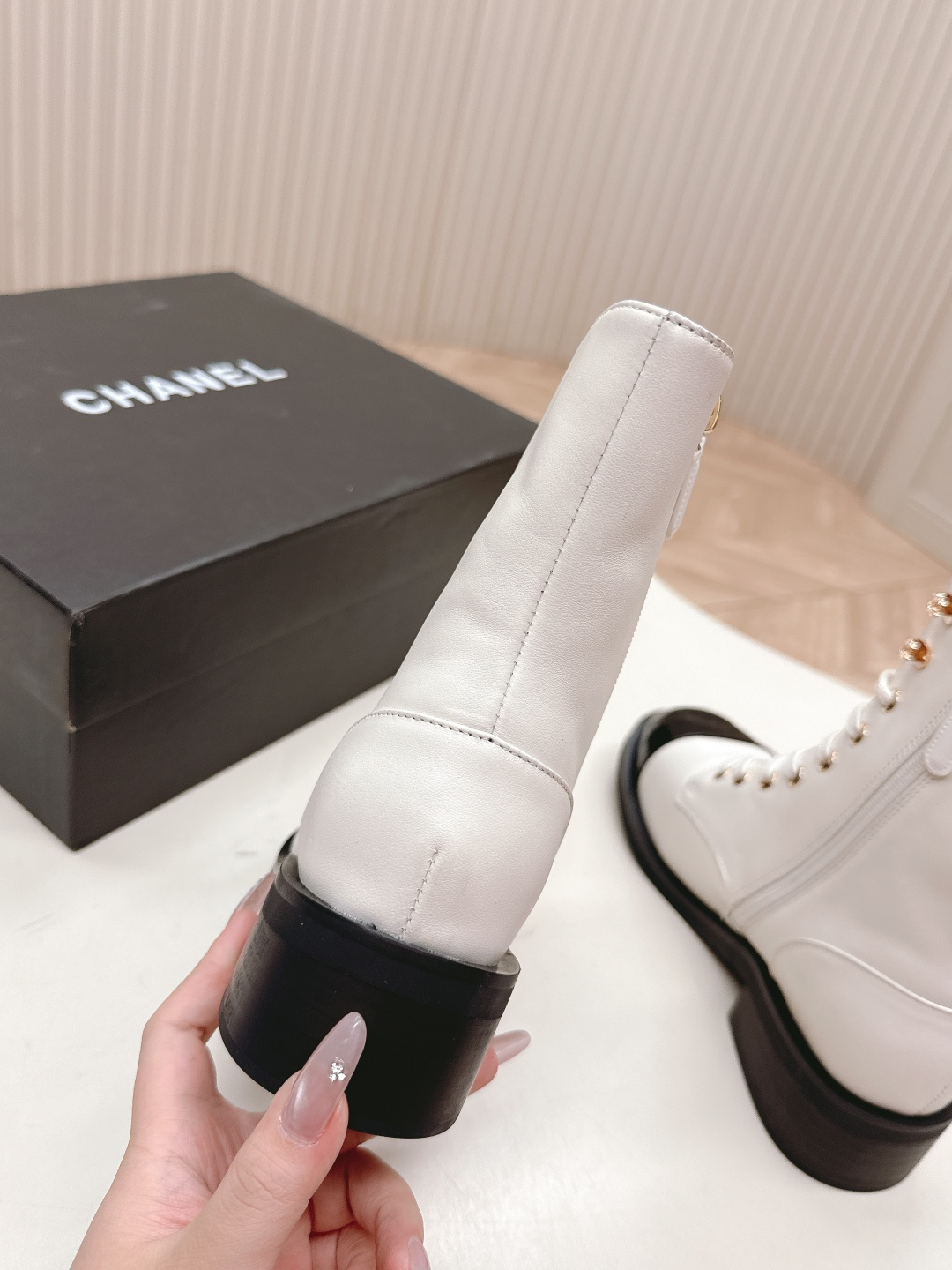 A pair of white leather lace-up combat boots with black patent leather cap toes and gold-tone hardware hooks. - Hình 8