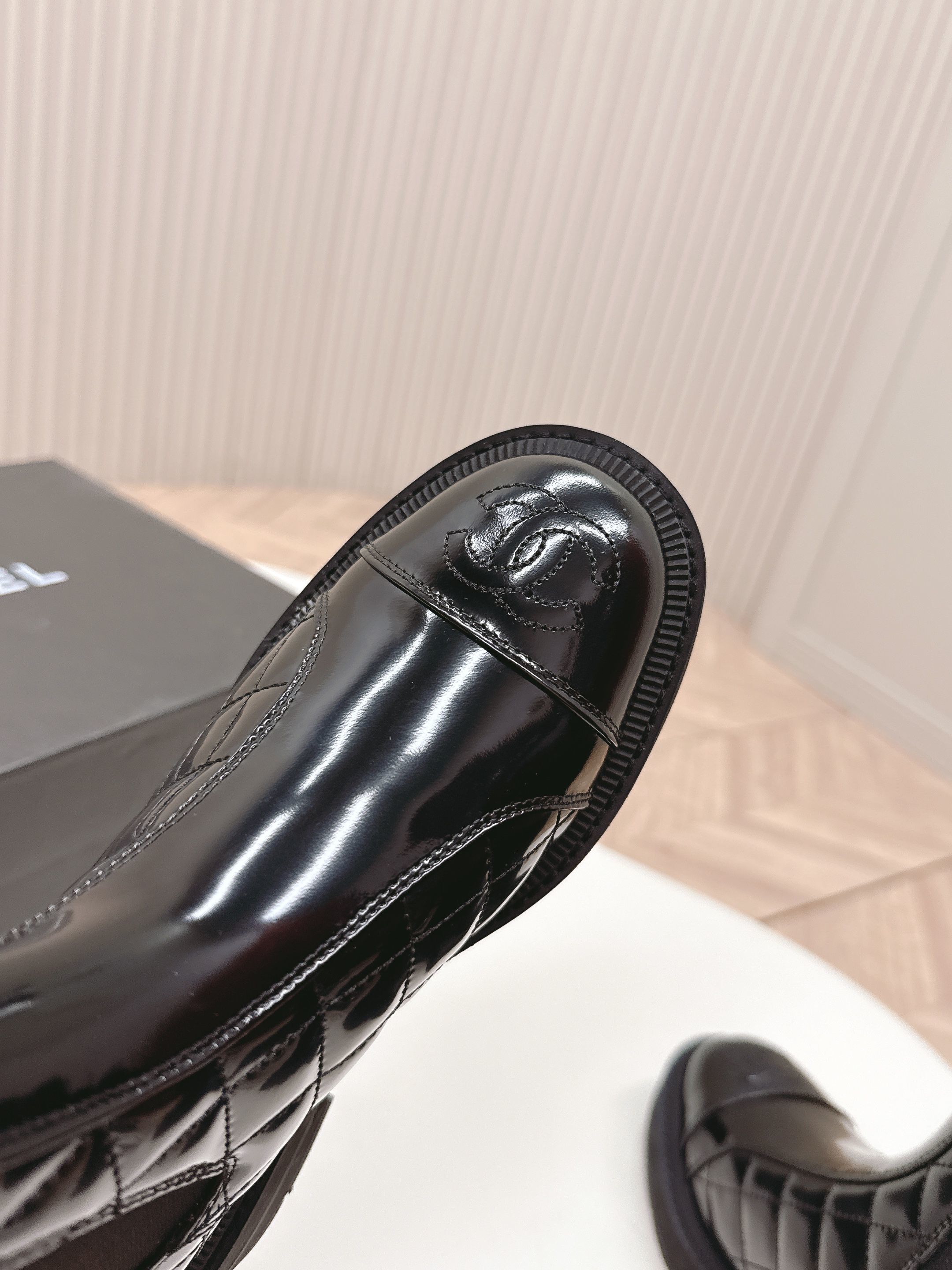 Pair of black Chanel quilted patent leather Chelsea boots with platform soles and embossed CC logo on the toe cap. - Hình 8