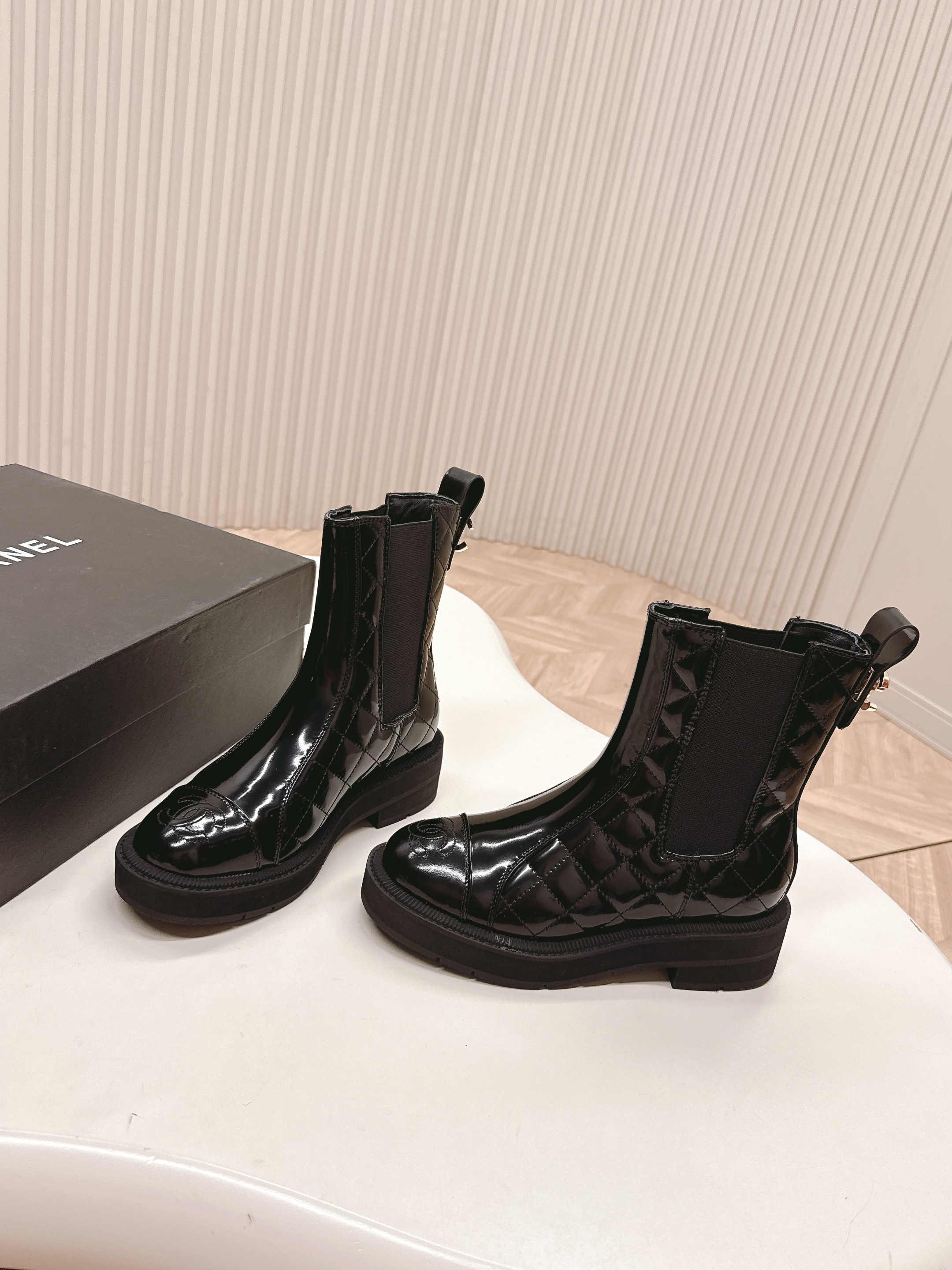 Pair of black Chanel quilted patent leather Chelsea boots with platform soles and embossed CC logo on the toe cap. - Hình 4