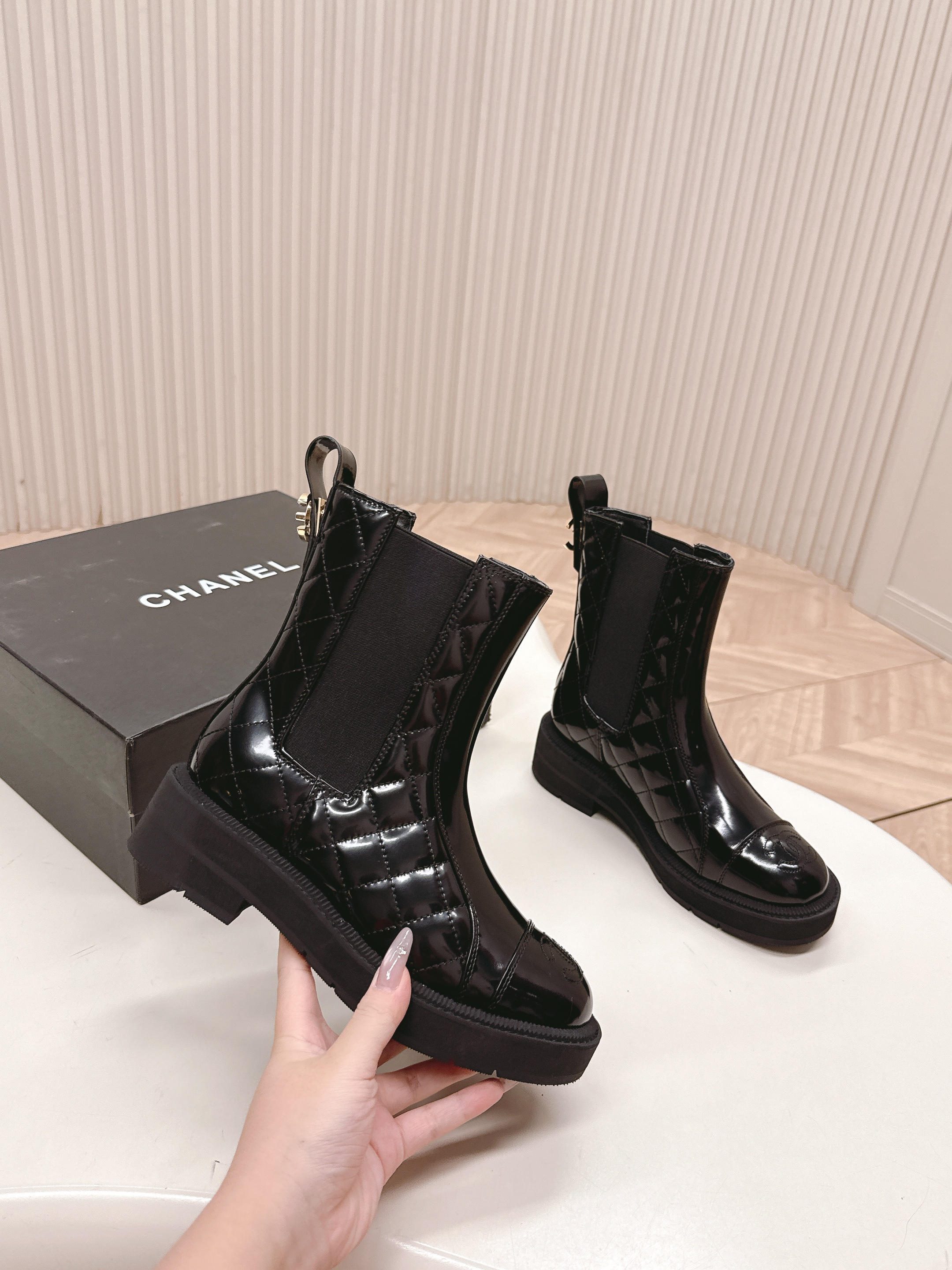 Pair of black Chanel quilted patent leather Chelsea boots with platform soles and embossed CC logo on the toe cap. - Hình 3