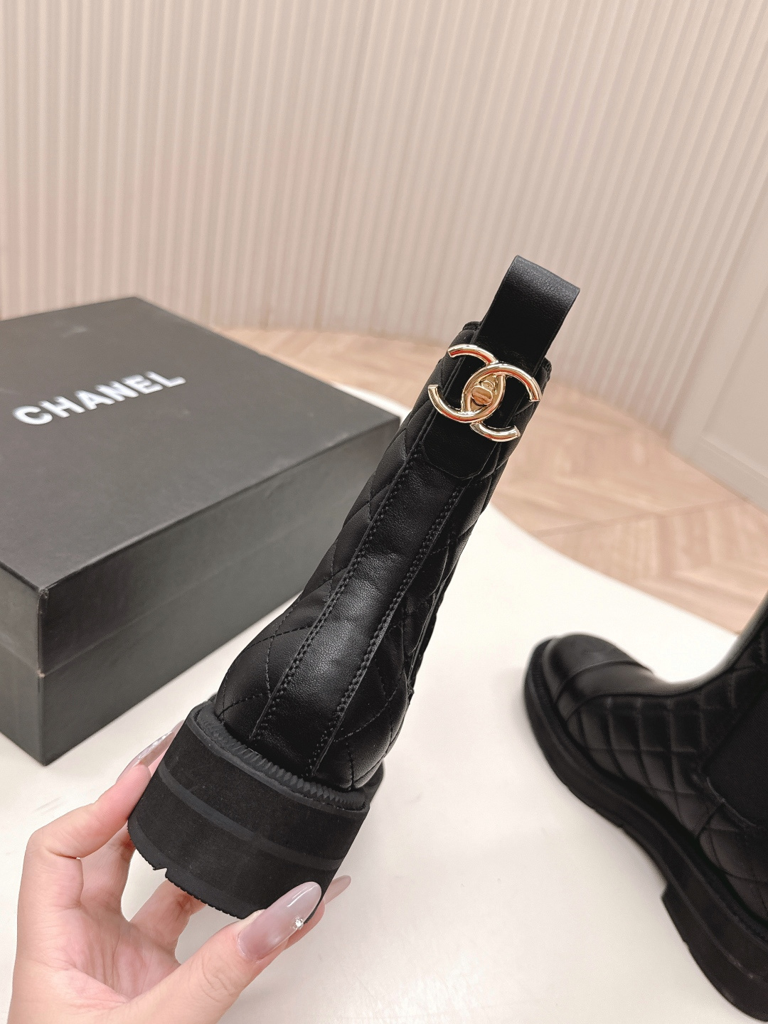A pair of black quilted leather Chanel Chelsea boots with embossed CC logo on the toe and a chunky rubber sole. - Hình 9