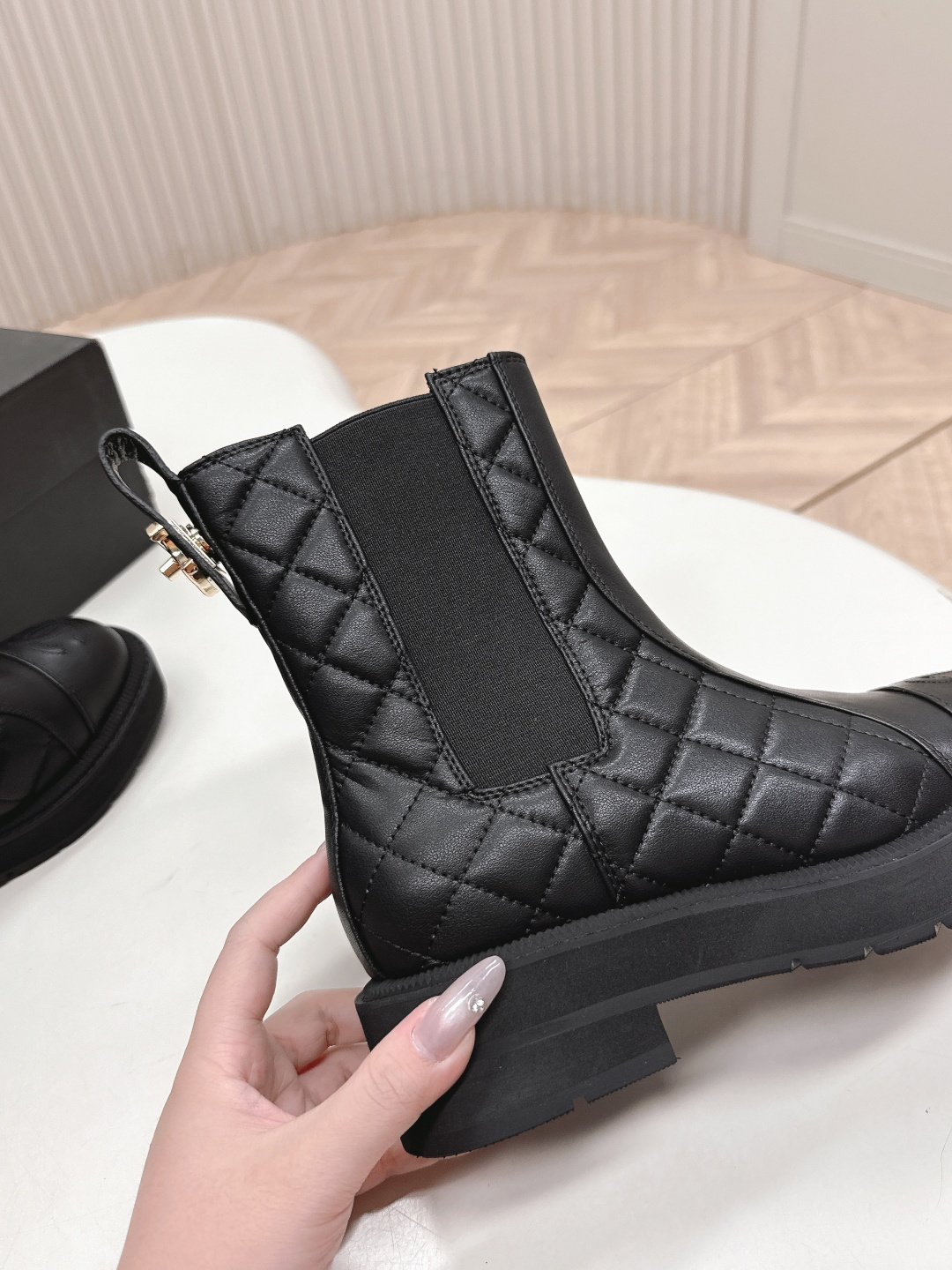 A pair of black quilted leather Chanel Chelsea boots with embossed CC logo on the toe and a chunky rubber sole. - Hình 8