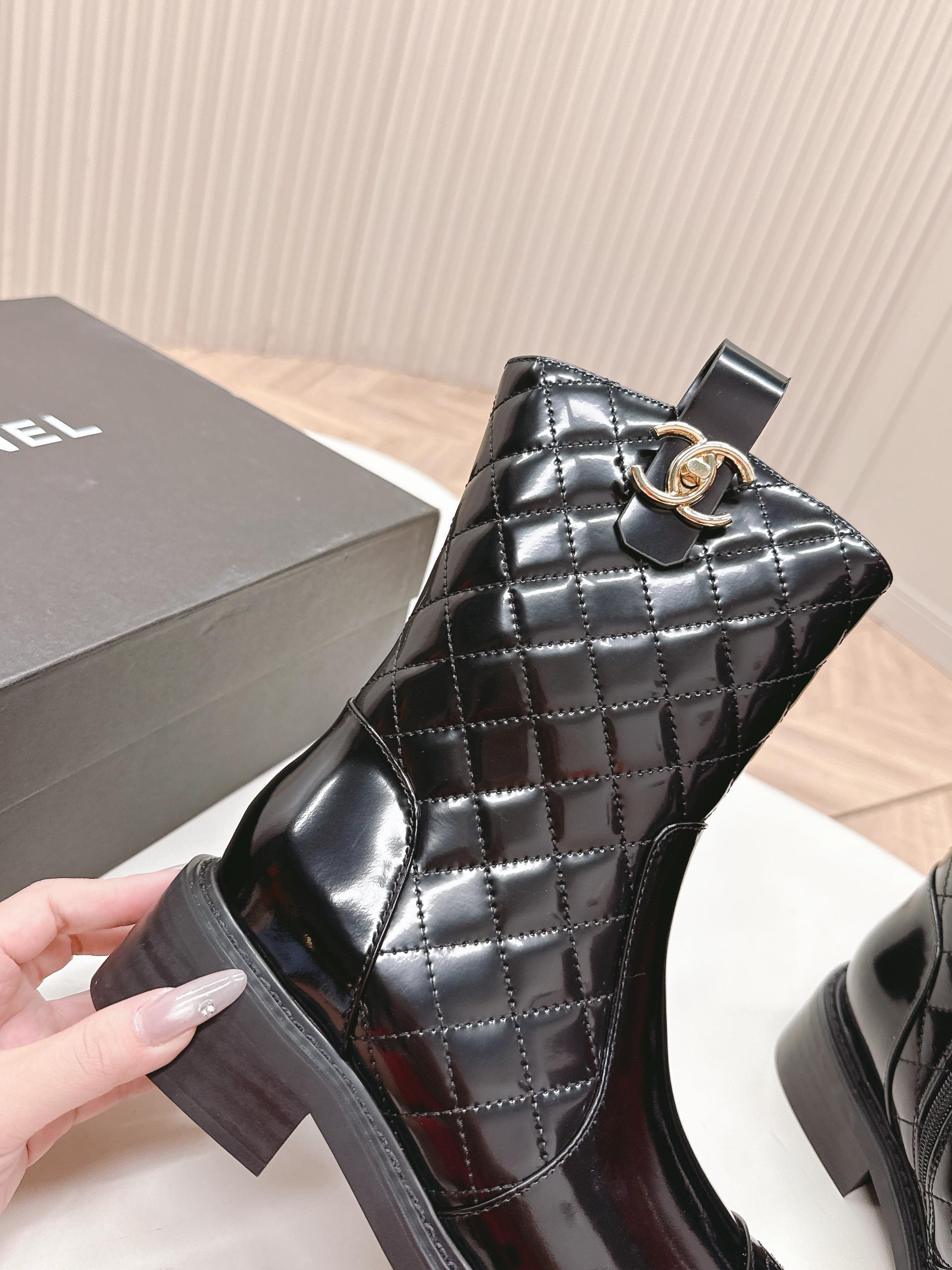 A pair of black Chanel quilted patent leather boots with gold CC logo and side zipper on a white surface. - Hình 3
