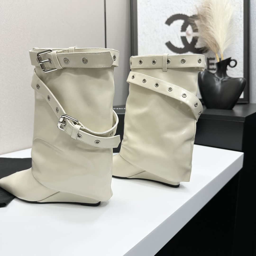 A pair of cream-colored slouchy leather wedge boots with pointed toes and double buckle strap details on a black display box. - Hình 5
