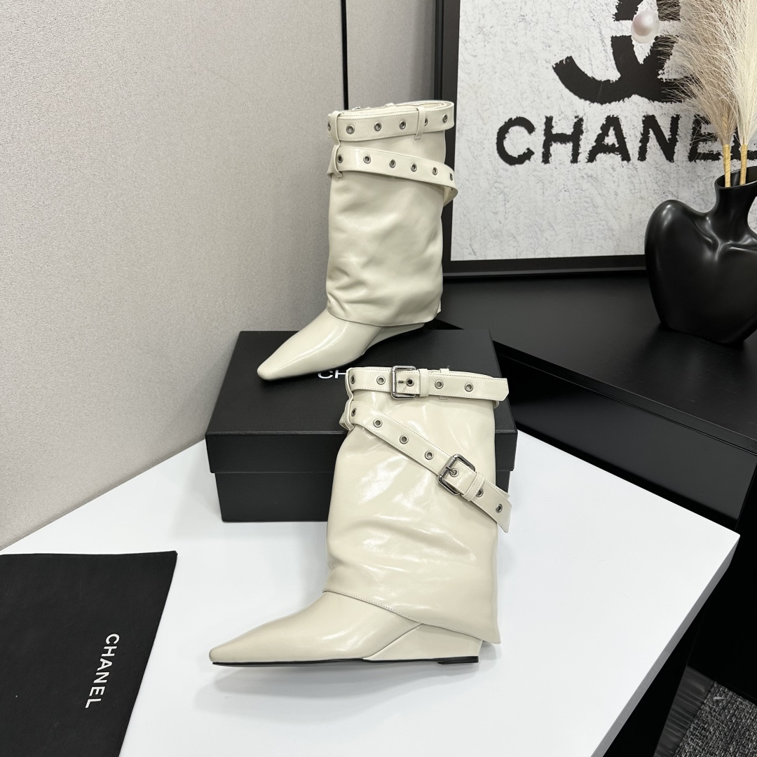 A pair of cream-colored slouchy leather wedge boots with pointed toes and double buckle strap details on a black display box. - Hình 3