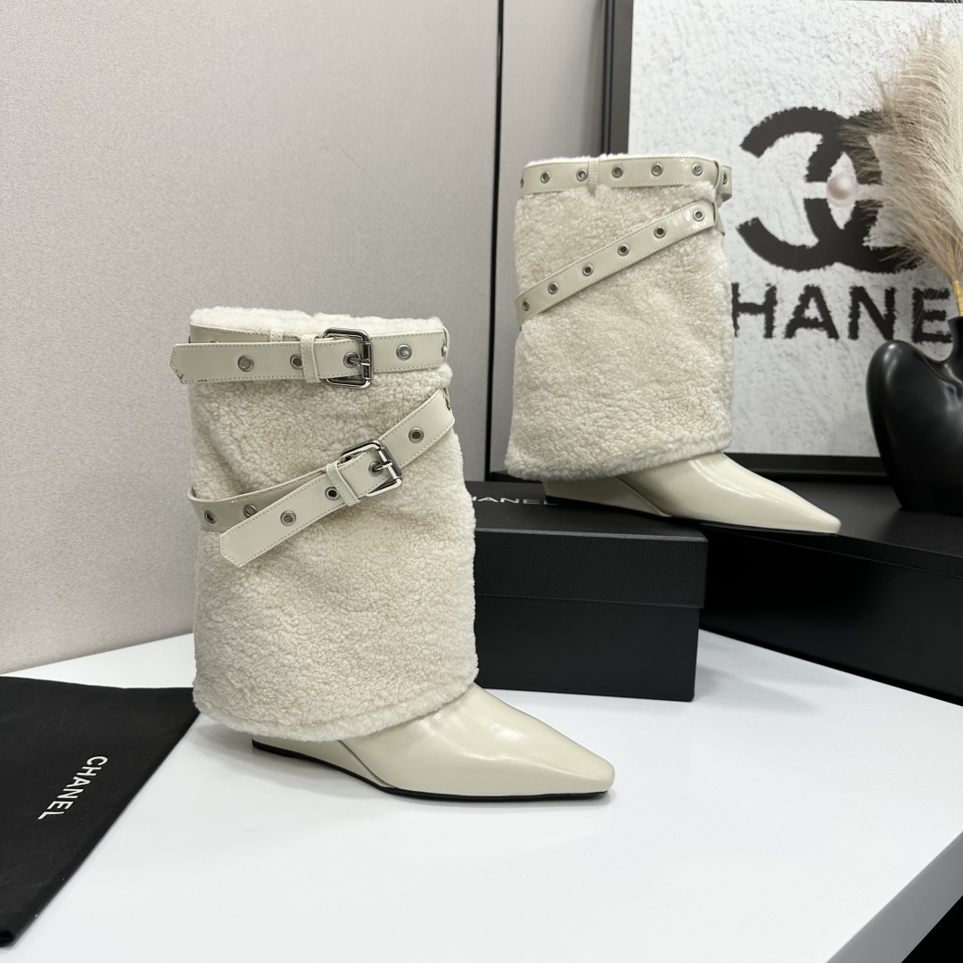Cream-colored pointed toe wedge boots featuring a plush faux fur shaft and decorative silver buckle straps on a black display box. - Hình 9