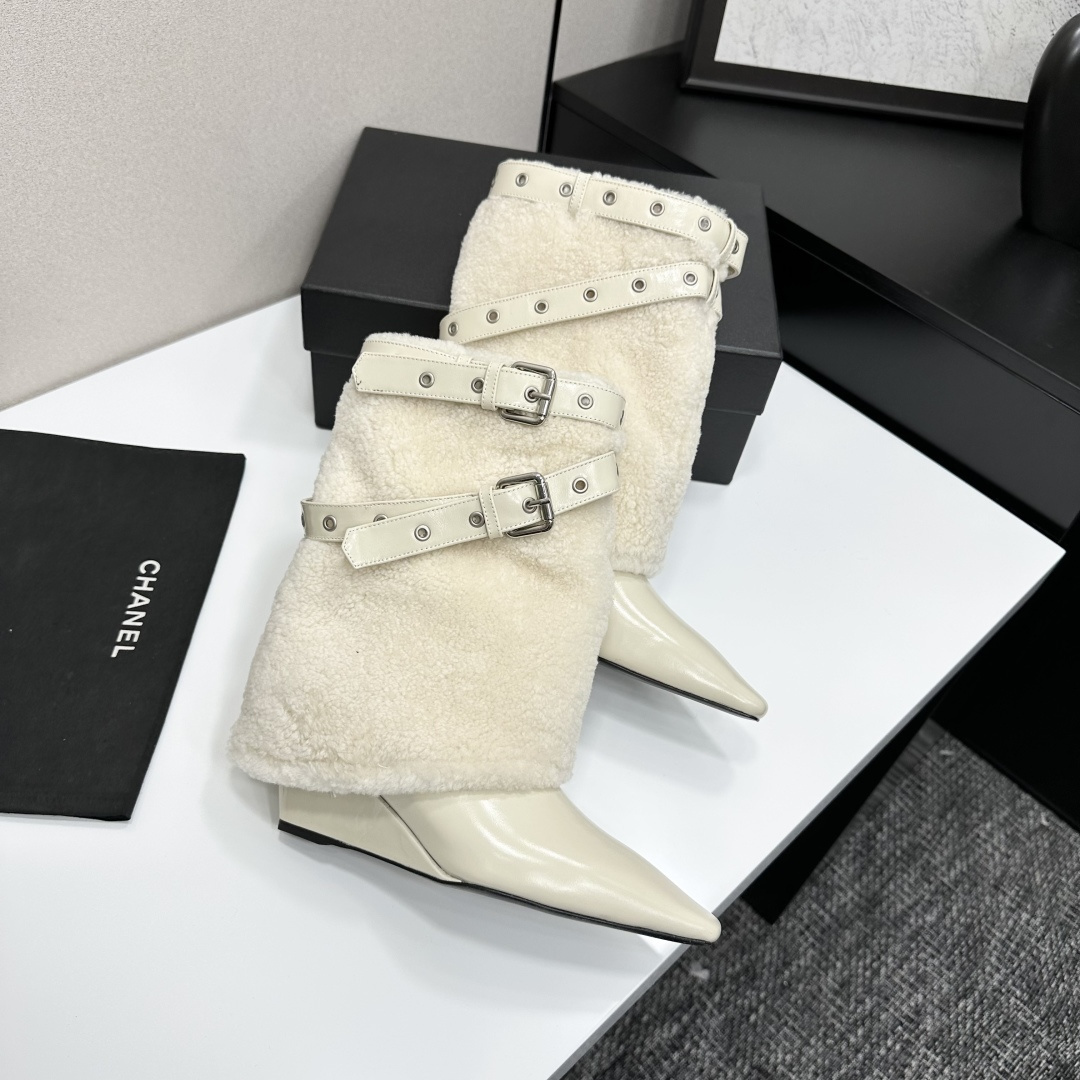 Cream-colored pointed toe wedge boots featuring a plush faux fur shaft and decorative silver buckle straps on a black display box. - Hình 7