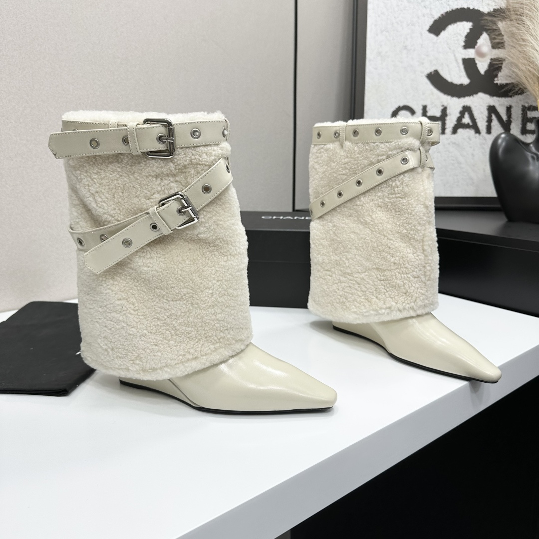 Cream-colored pointed toe wedge boots featuring a plush faux fur shaft and decorative silver buckle straps on a black display box. - Hình 6