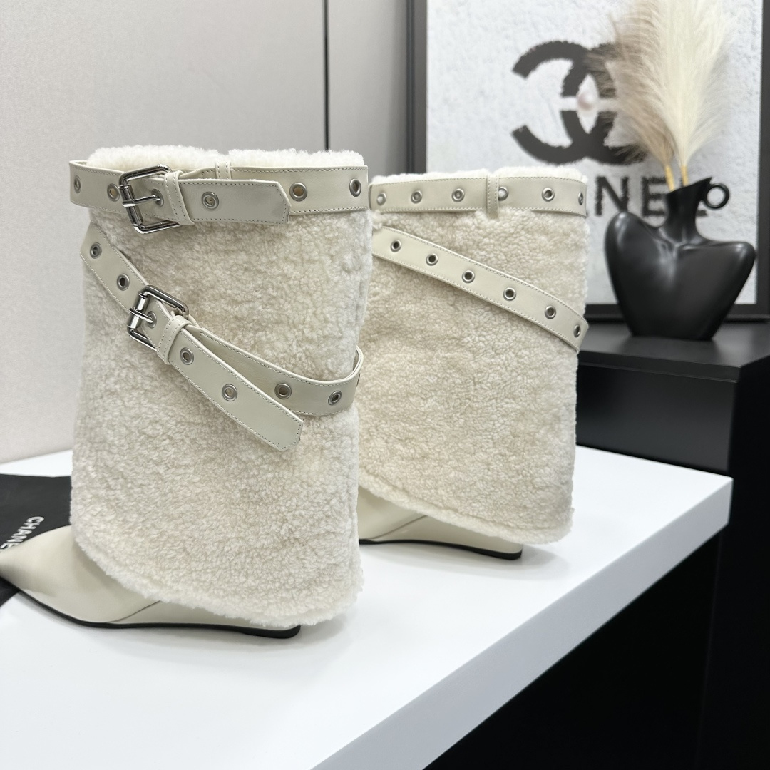 Cream-colored pointed toe wedge boots featuring a plush faux fur shaft and decorative silver buckle straps on a black display box. - Hình 5