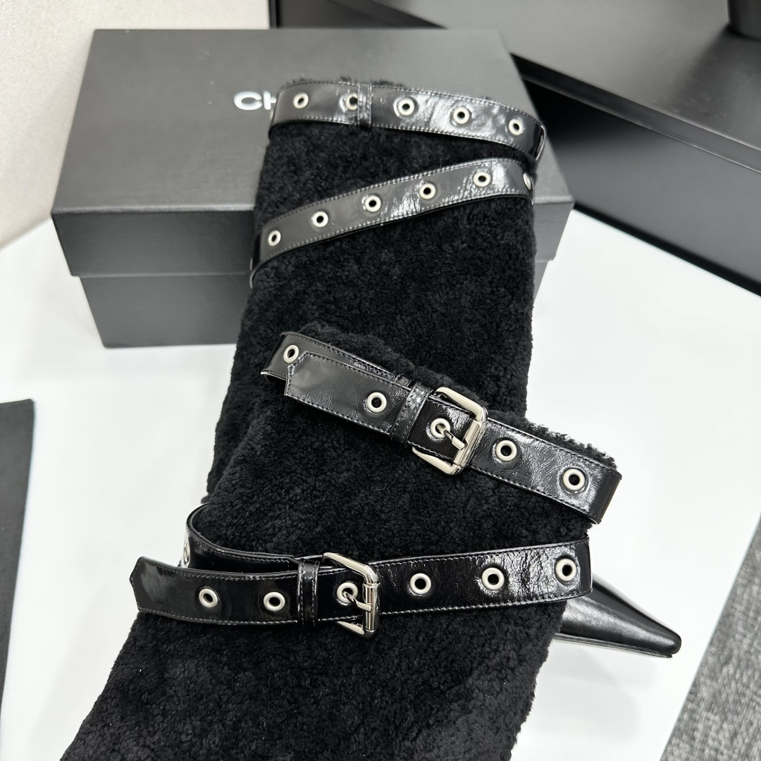 Luxury black shearling ankle boots with silver buckle straps and pointed toes sitting on a black designer box. - Hình 8