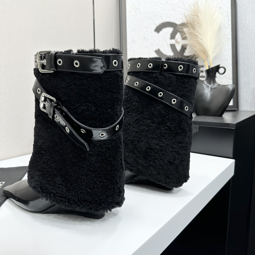 Luxury black shearling ankle boots with silver buckle straps and pointed toes sitting on a black designer box. - Hình 5