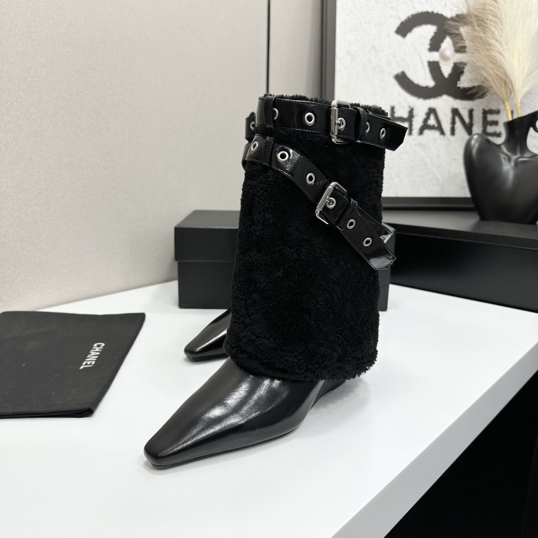 Luxury black shearling ankle boots with silver buckle straps and pointed toes sitting on a black designer box. - Hình 4