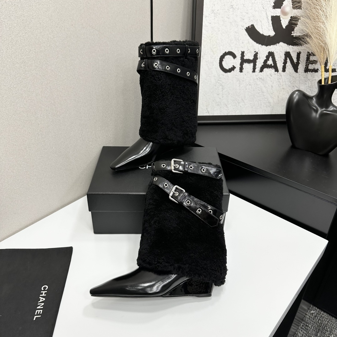 Luxury black shearling ankle boots with silver buckle straps and pointed toes sitting on a black designer box. - Hình 3