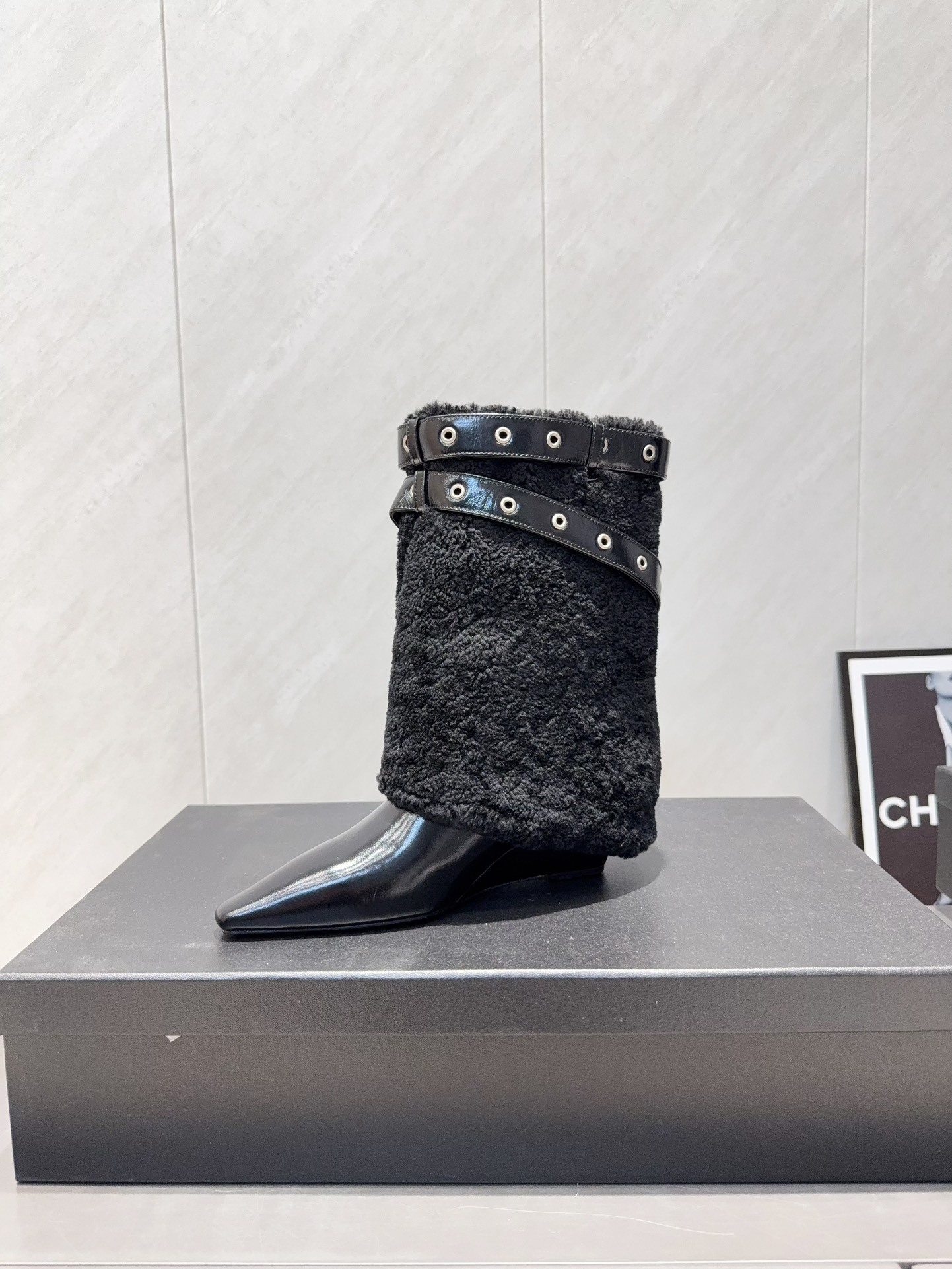 A pair of Chanel black patent leather and shearling ankle boots with silver eyelet buckles and pointed toes on a black box. - Hình 7