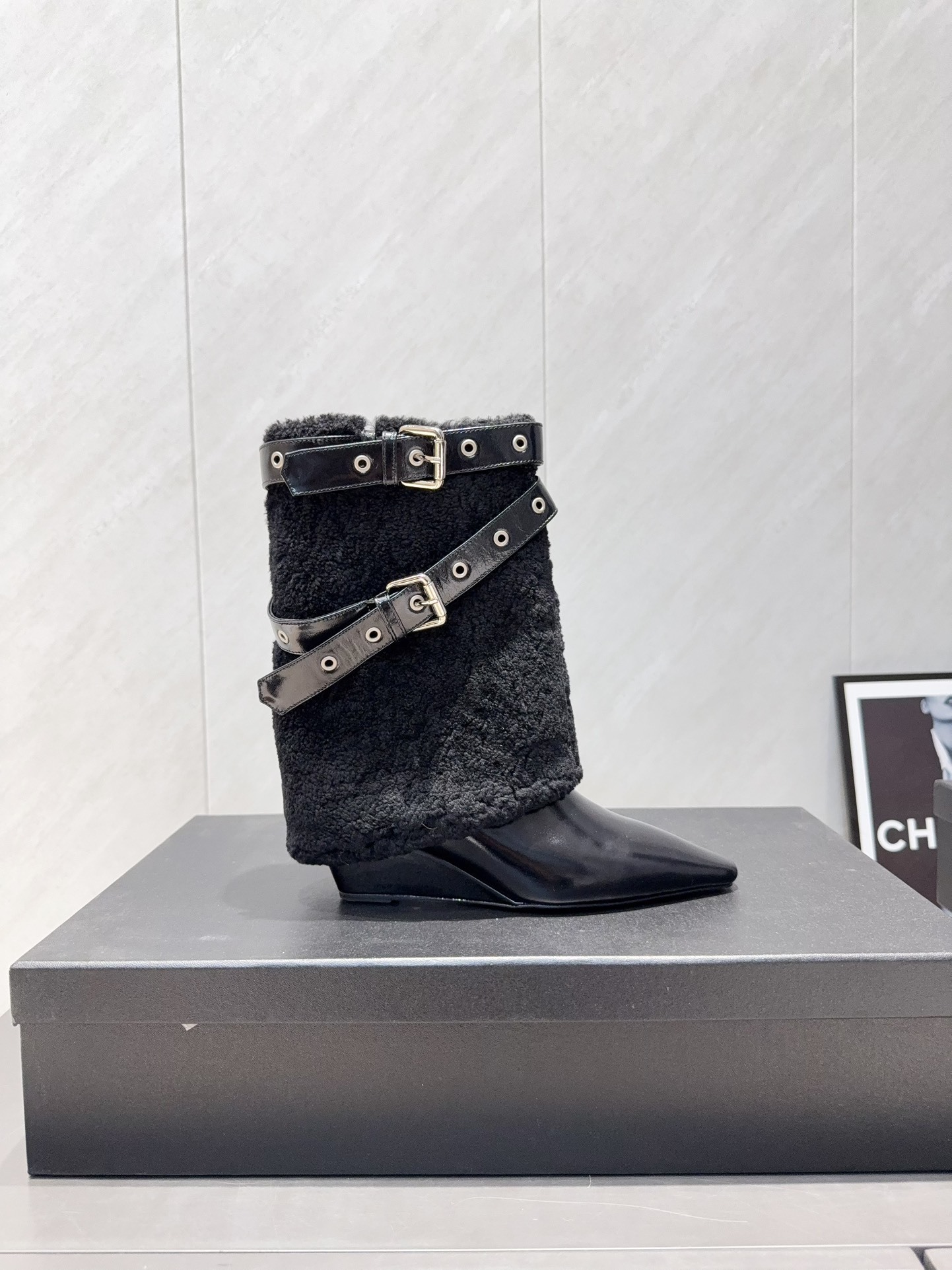 A pair of Chanel black patent leather and shearling ankle boots with silver eyelet buckles and pointed toes on a black box. - Hình 5