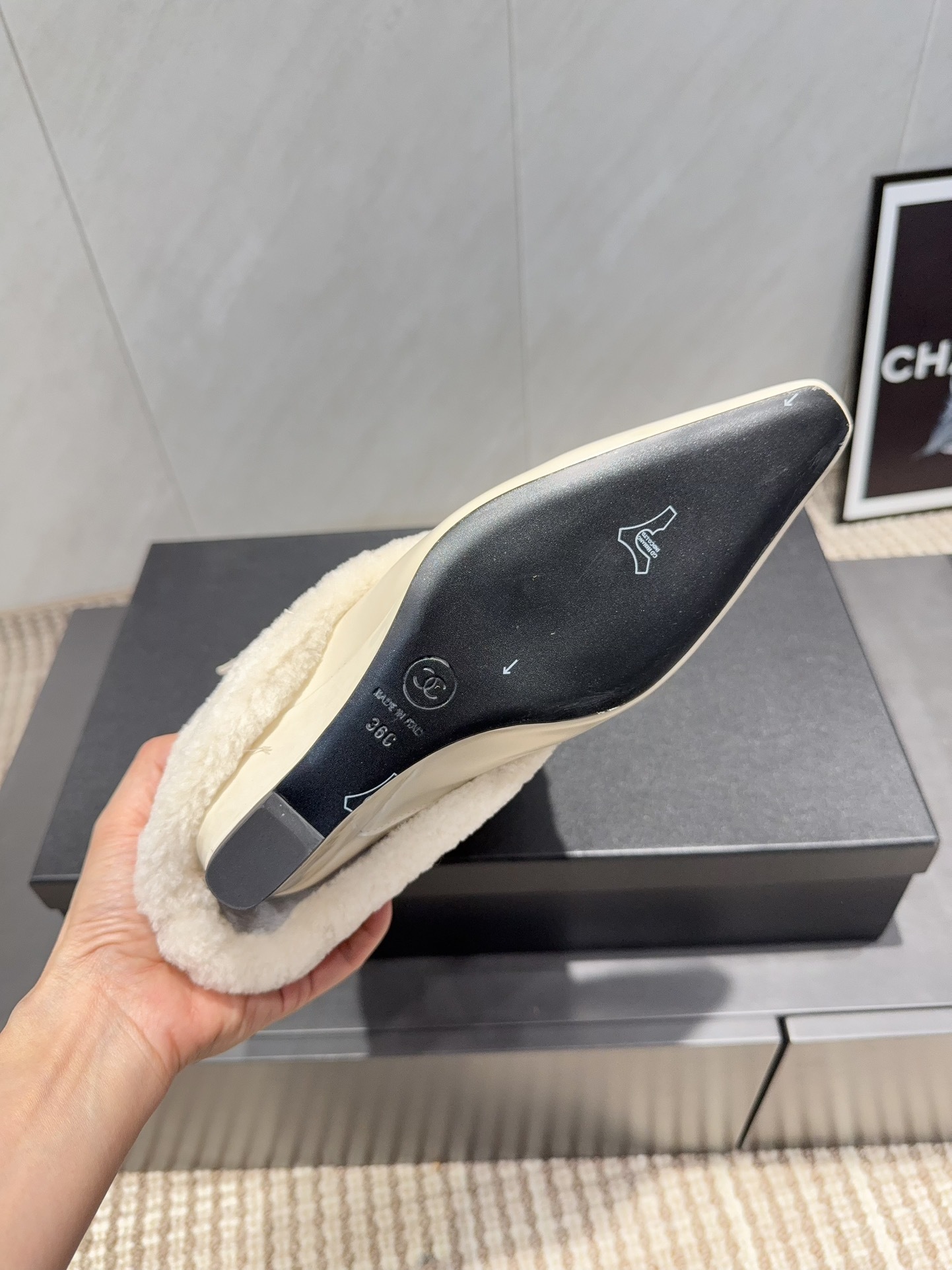 Pair of luxury cream pointed toe ankle boots with plush shearling shafts and decorative buckle straps displayed on a black box. - Hình 9