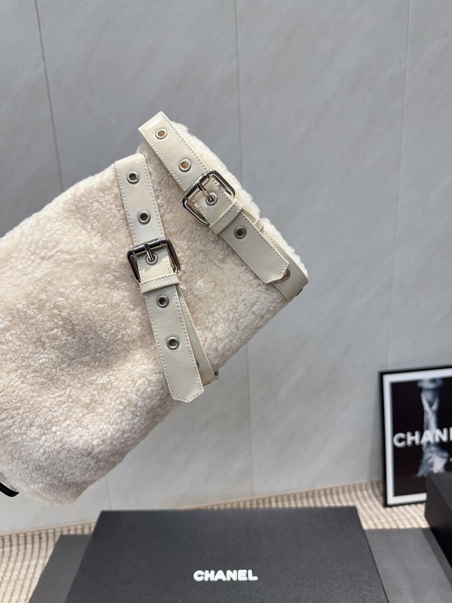 Pair of luxury cream pointed toe ankle boots with plush shearling shafts and decorative buckle straps displayed on a black box. - Hình 7