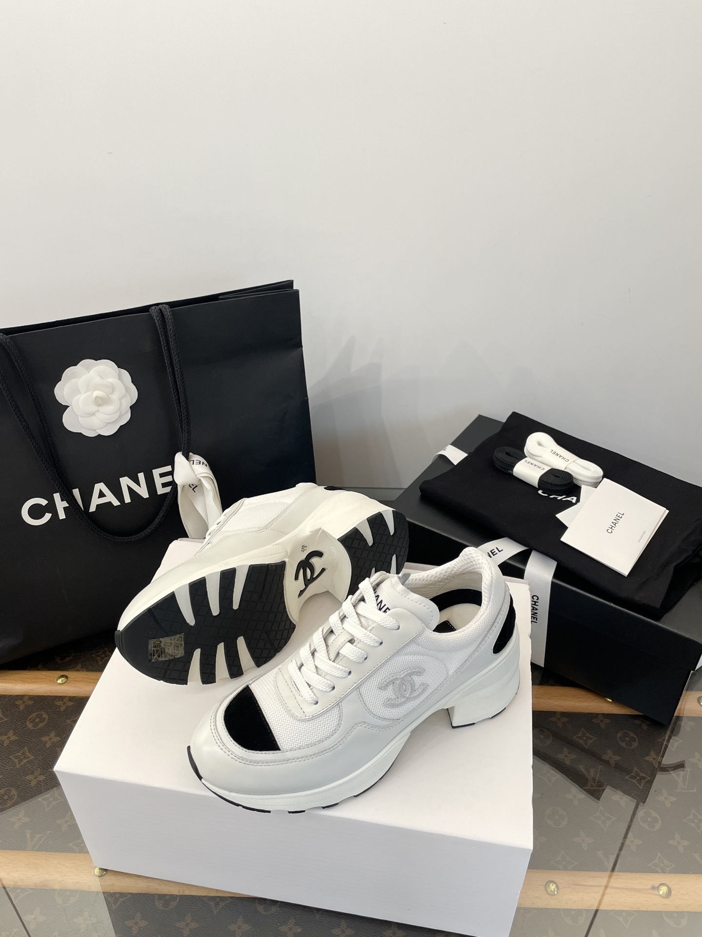 Luxury Chanel white and black mesh leather sneakers with chunky heels on a white box with branded packaging. - Hình 9