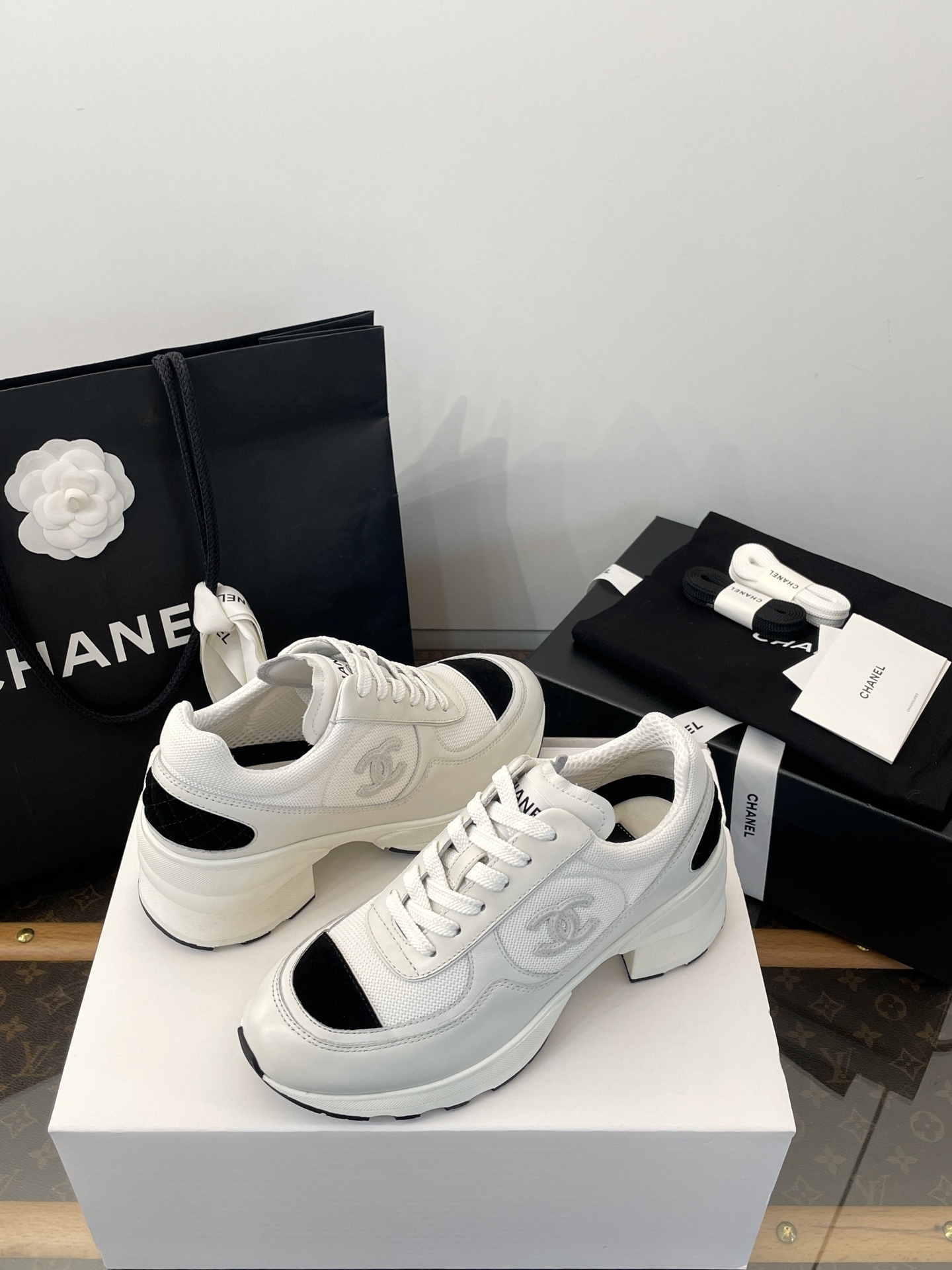 Luxury Chanel white and black mesh leather sneakers with chunky heels on a white box with branded packaging. - Hình 8