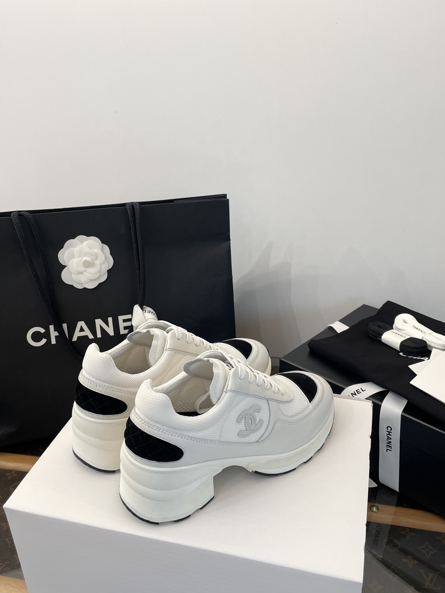 Luxury Chanel white and black mesh leather sneakers with chunky heels on a white box with branded packaging. - Hình 7
