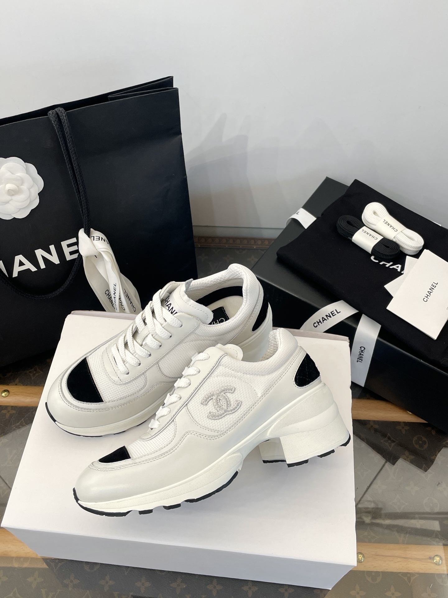 Luxury Chanel white and black mesh leather sneakers with chunky heels on a white box with branded packaging. - Hình 6