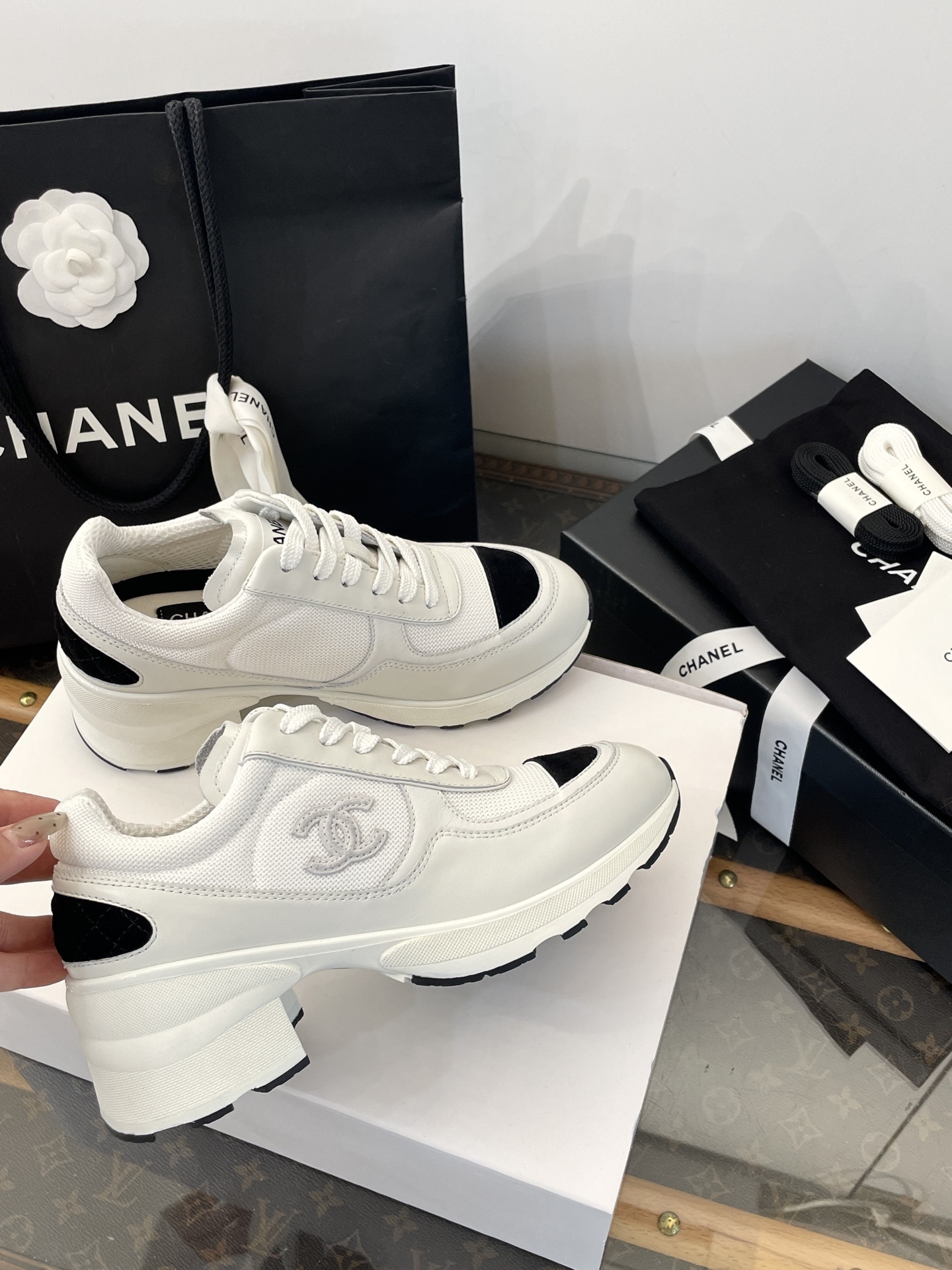 Luxury Chanel white and black mesh leather sneakers with chunky heels on a white box with branded packaging. - Hình 4
