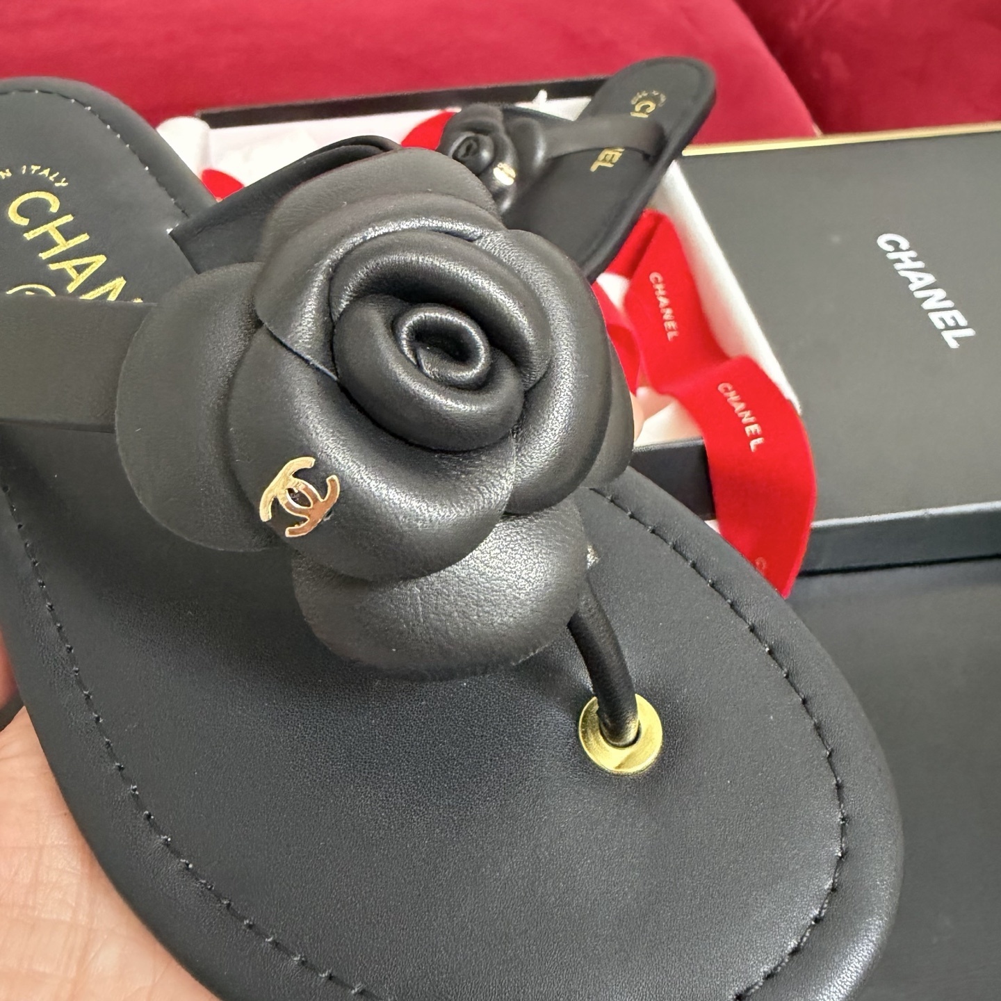 Black Chanel leather thong sandals with 3D Camellia flower and gold CC logo in a luxury gift box with red ribbons. - Hình 6