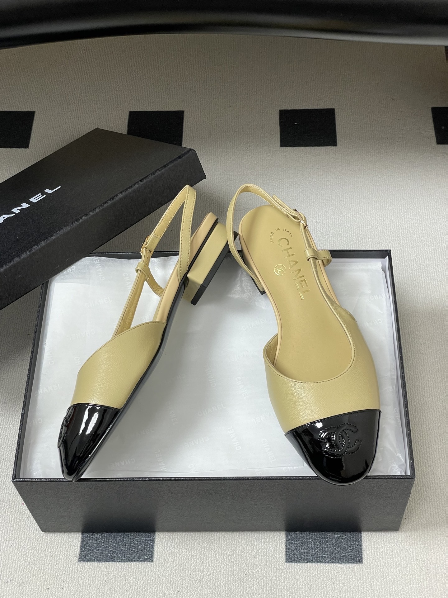 A pair of classic Chanel beige leather slingback pumps with black patent leather cap toes and low block heels. - Hình 6