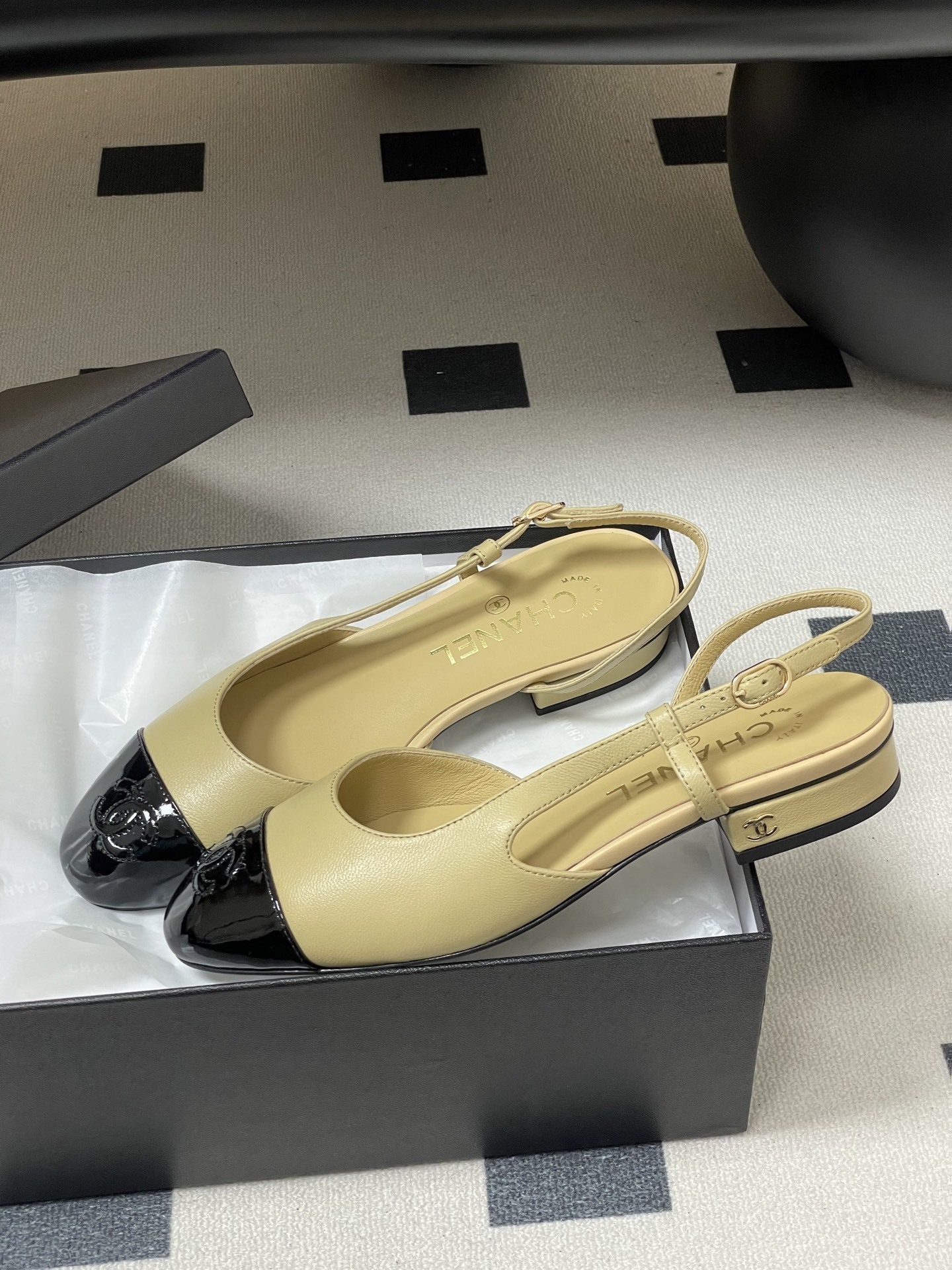 A pair of classic Chanel beige leather slingback pumps with black patent leather cap toes and low block heels. - Hình 4
