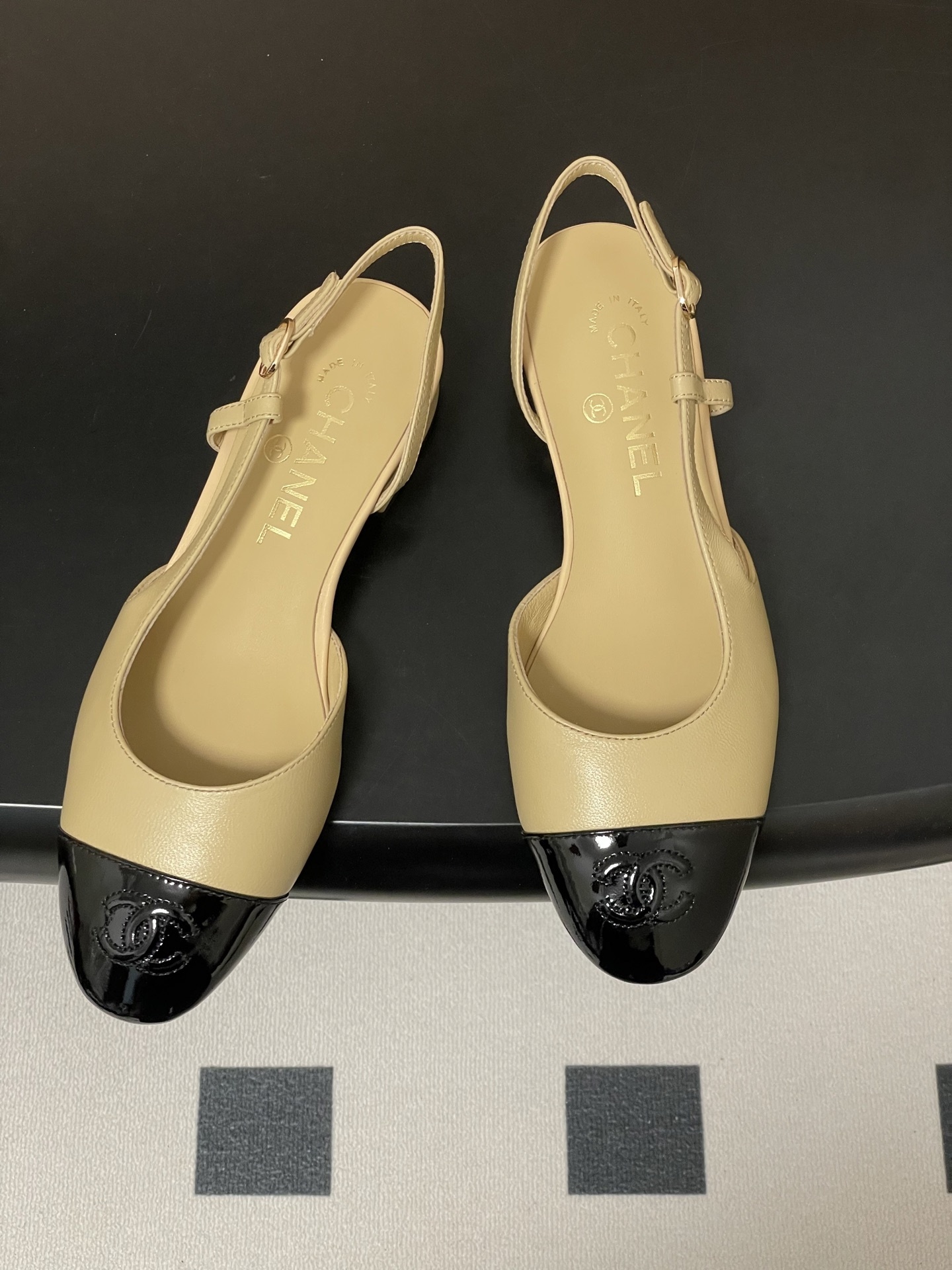 A pair of classic Chanel beige leather slingback pumps with black patent leather cap toes and low block heels. - Hình 2