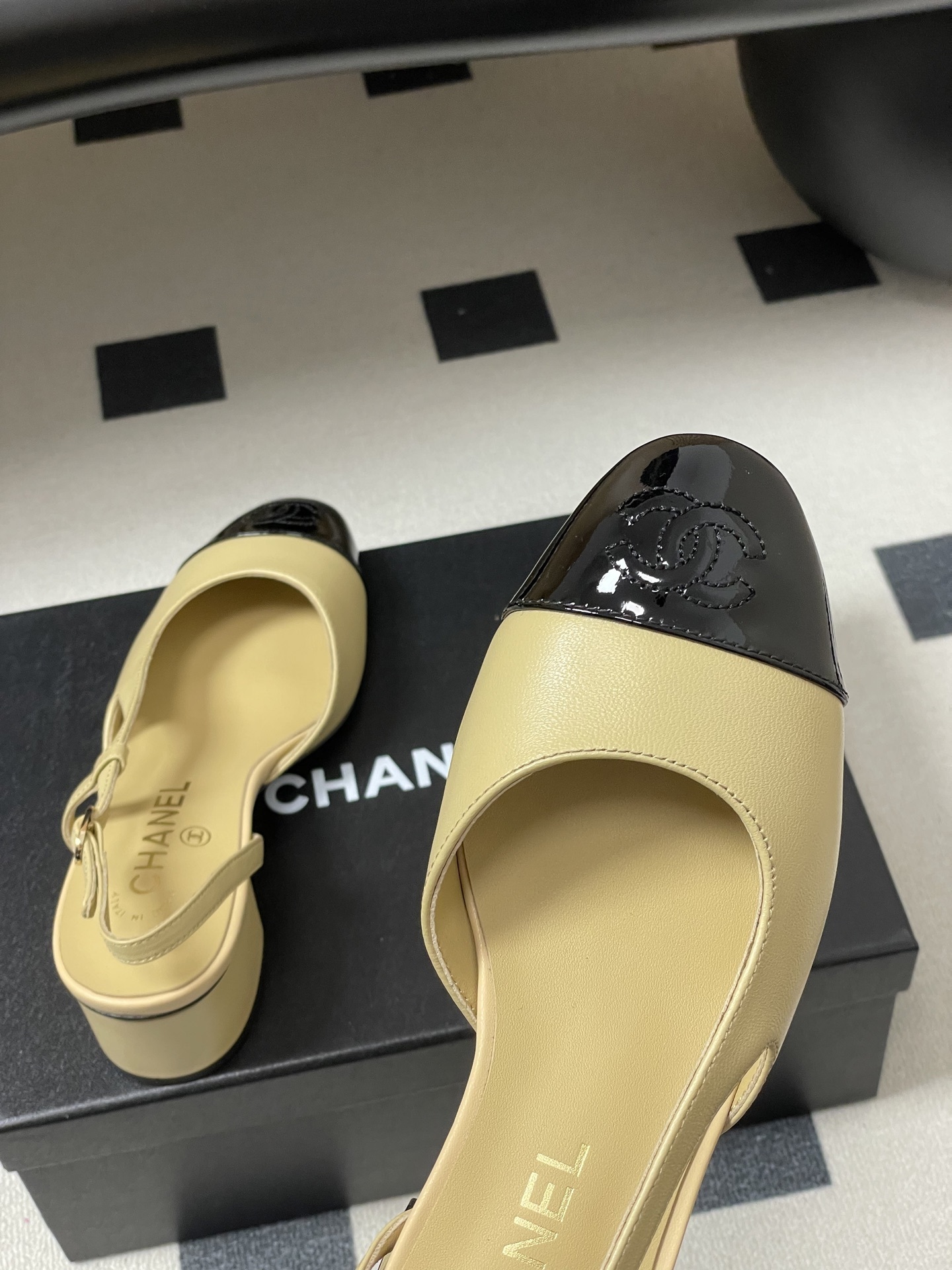 A pair of luxury Chanel two-tone slingback pumps in beige leather with a black patent leather toe cap and block heel. - Hình 9