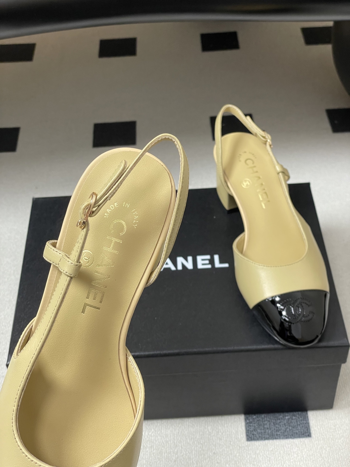 A pair of luxury Chanel two-tone slingback pumps in beige leather with a black patent leather toe cap and block heel. - Hình 7