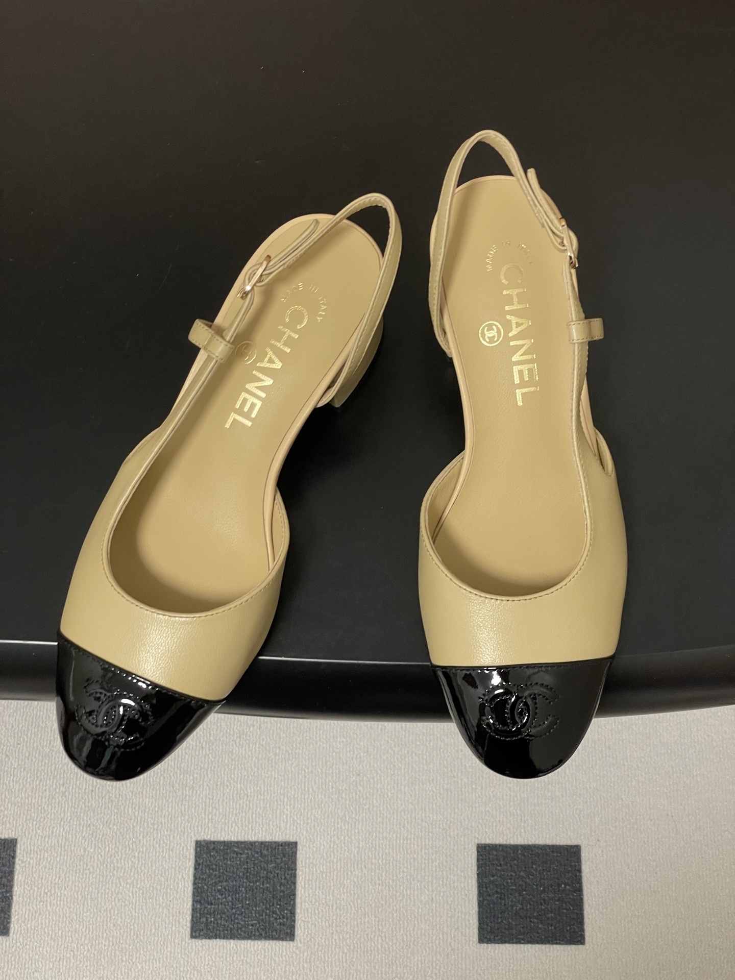 A pair of luxury Chanel two-tone slingback pumps in beige leather with a black patent leather toe cap and block heel. - Hình 2