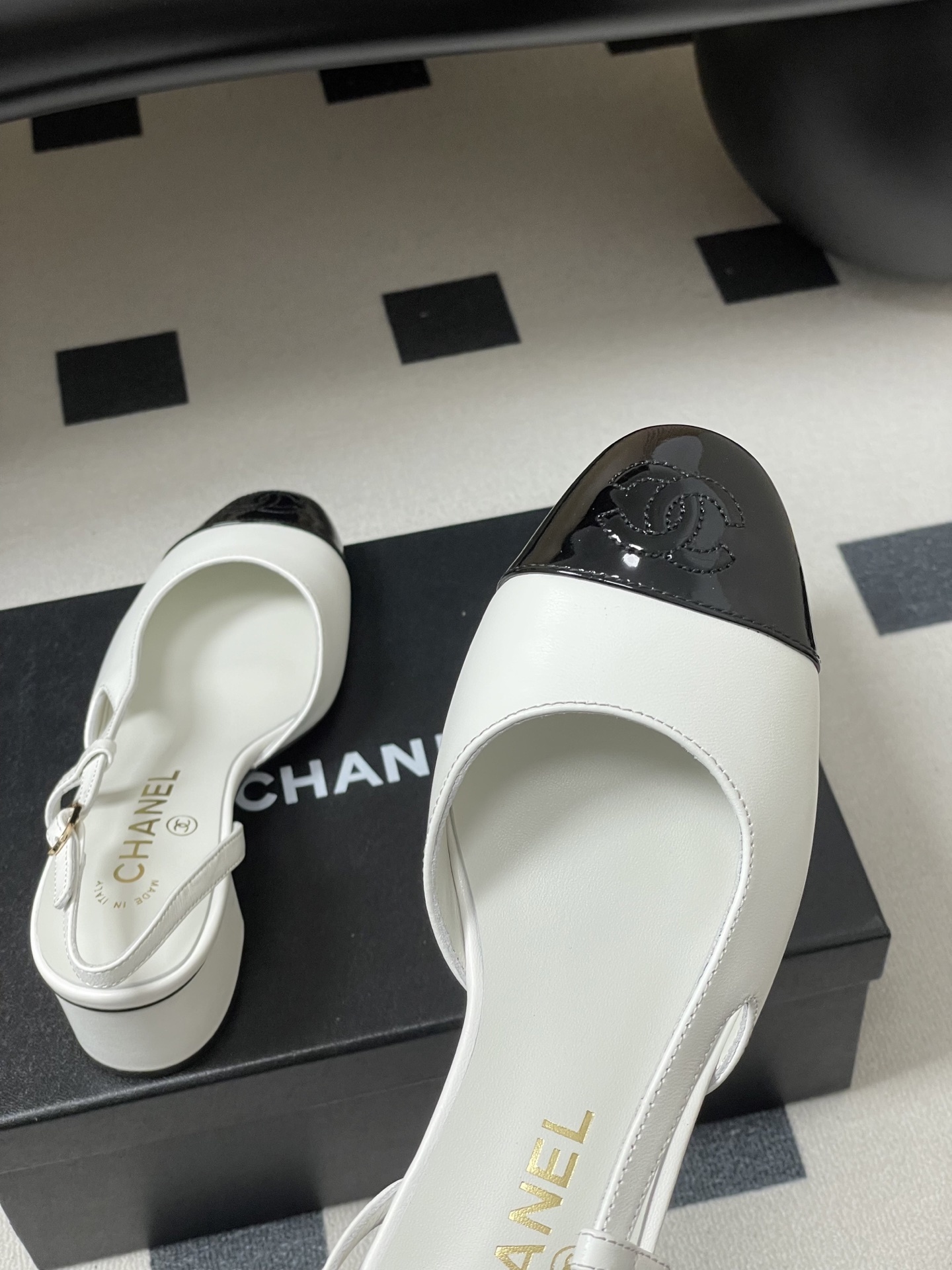 Luxury Chanel slingback pumps in white leather with black patent cap toe and block heel featuring gold CC logo. - Hình 9