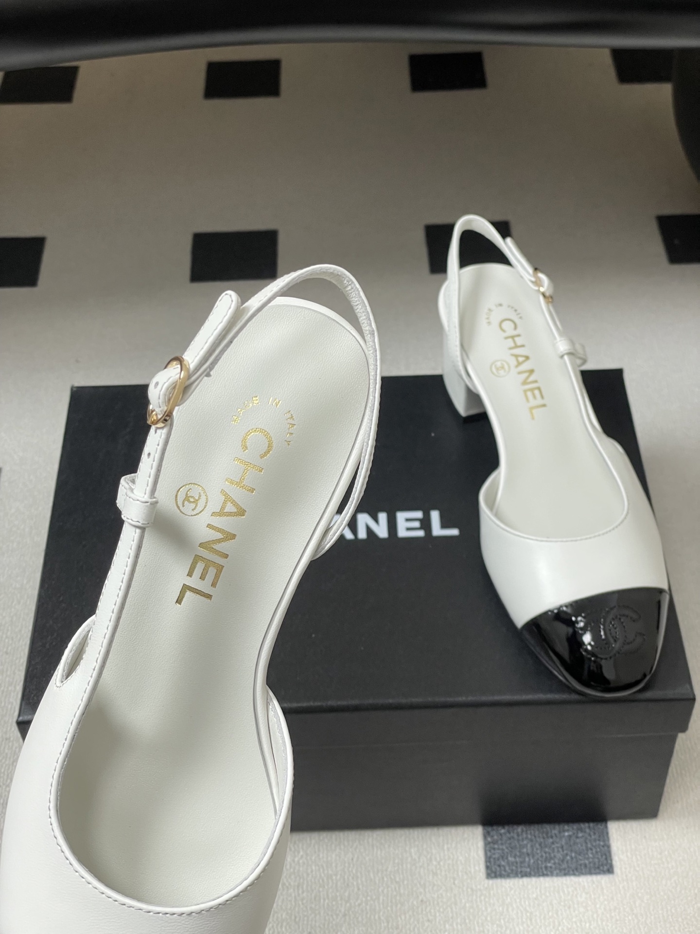 Luxury Chanel slingback pumps in white leather with black patent cap toe and block heel featuring gold CC logo. - Hình 7