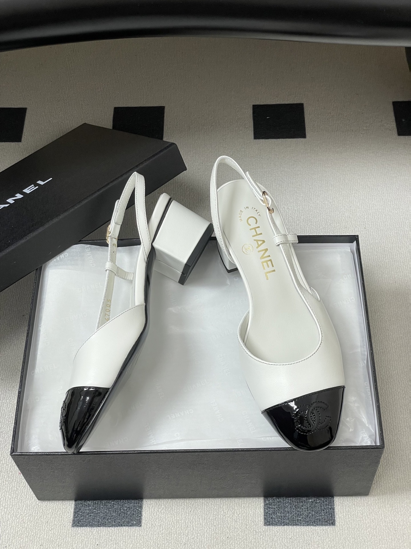 Luxury Chanel slingback pumps in white leather with black patent cap toe and block heel featuring gold CC logo. - Hình 6