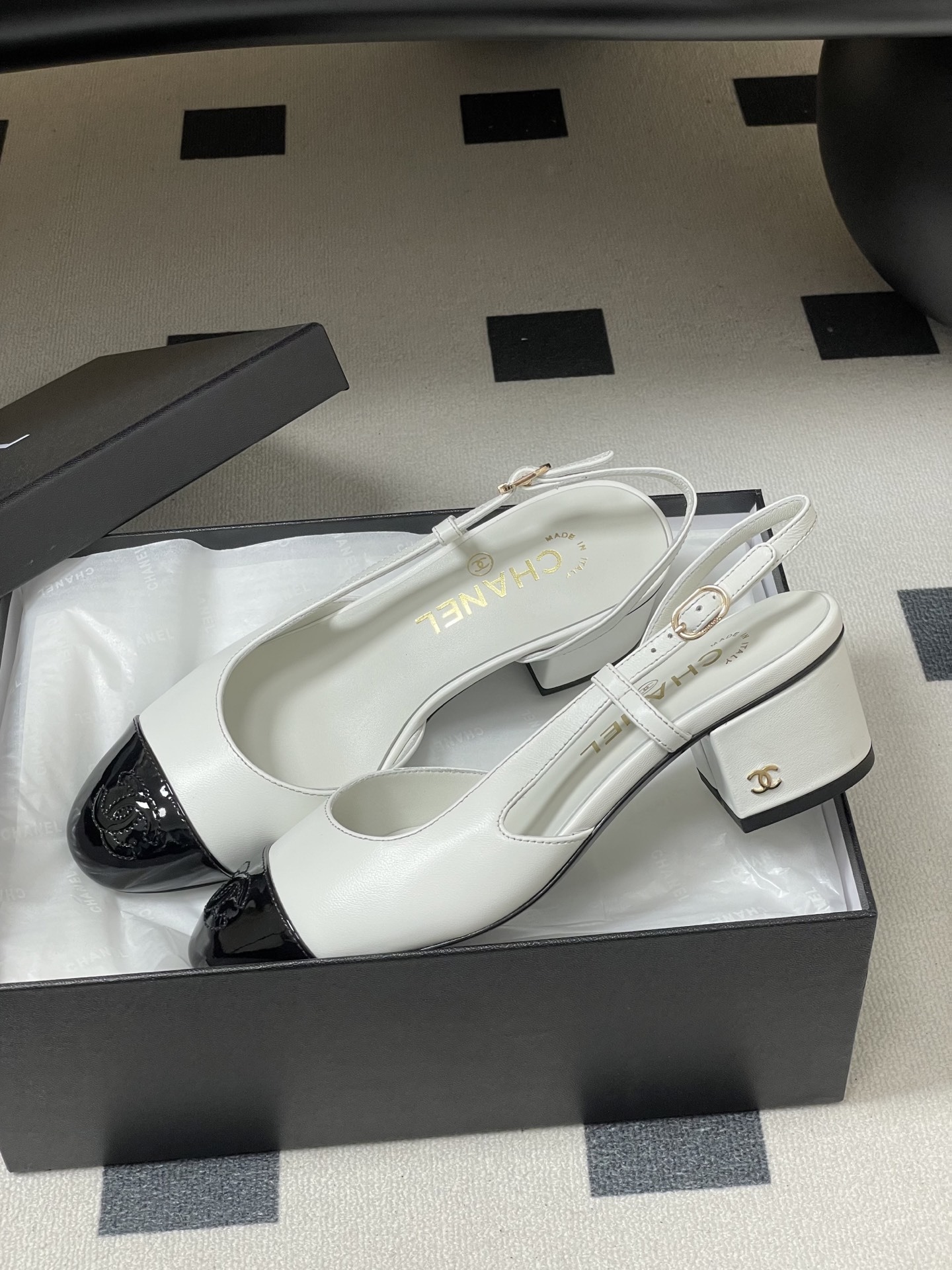 Luxury Chanel slingback pumps in white leather with black patent cap toe and block heel featuring gold CC logo. - Hình 4