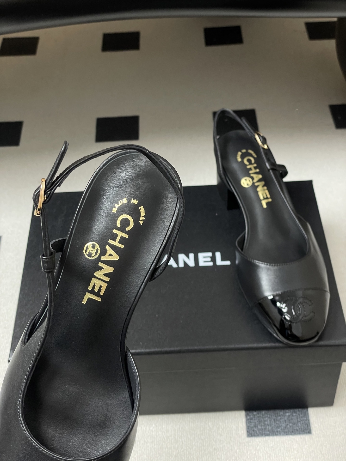 Pair of black Chanel slingback pumps with patent leather cap toe and gold CC logo on the block heel. - Hình 7