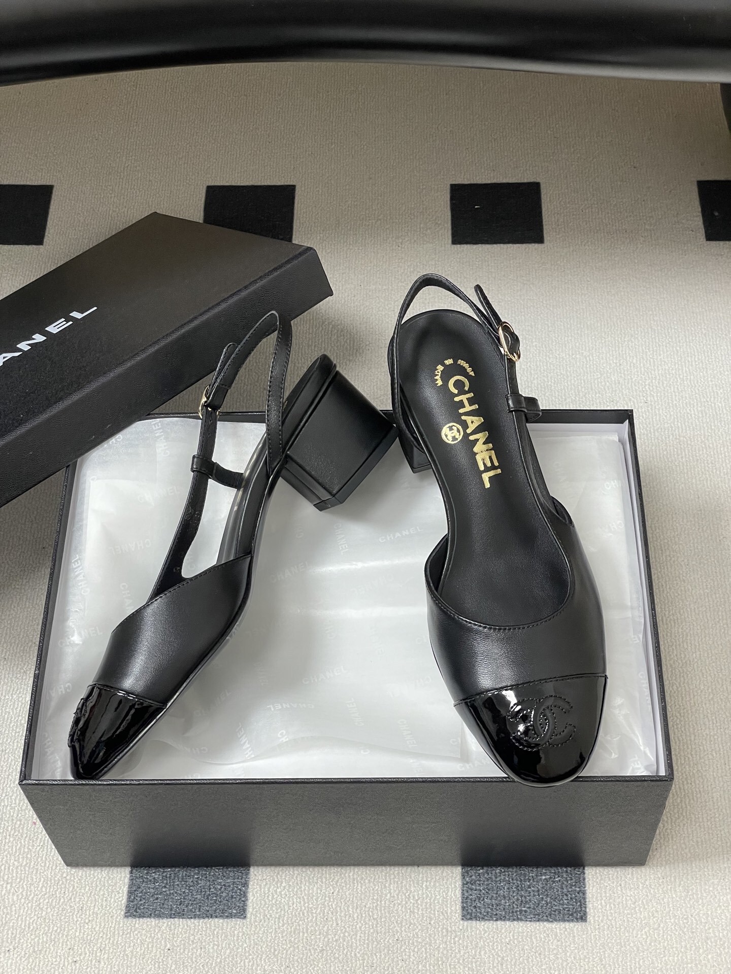 Pair of black Chanel slingback pumps with patent leather cap toe and gold CC logo on the block heel. - Hình 6