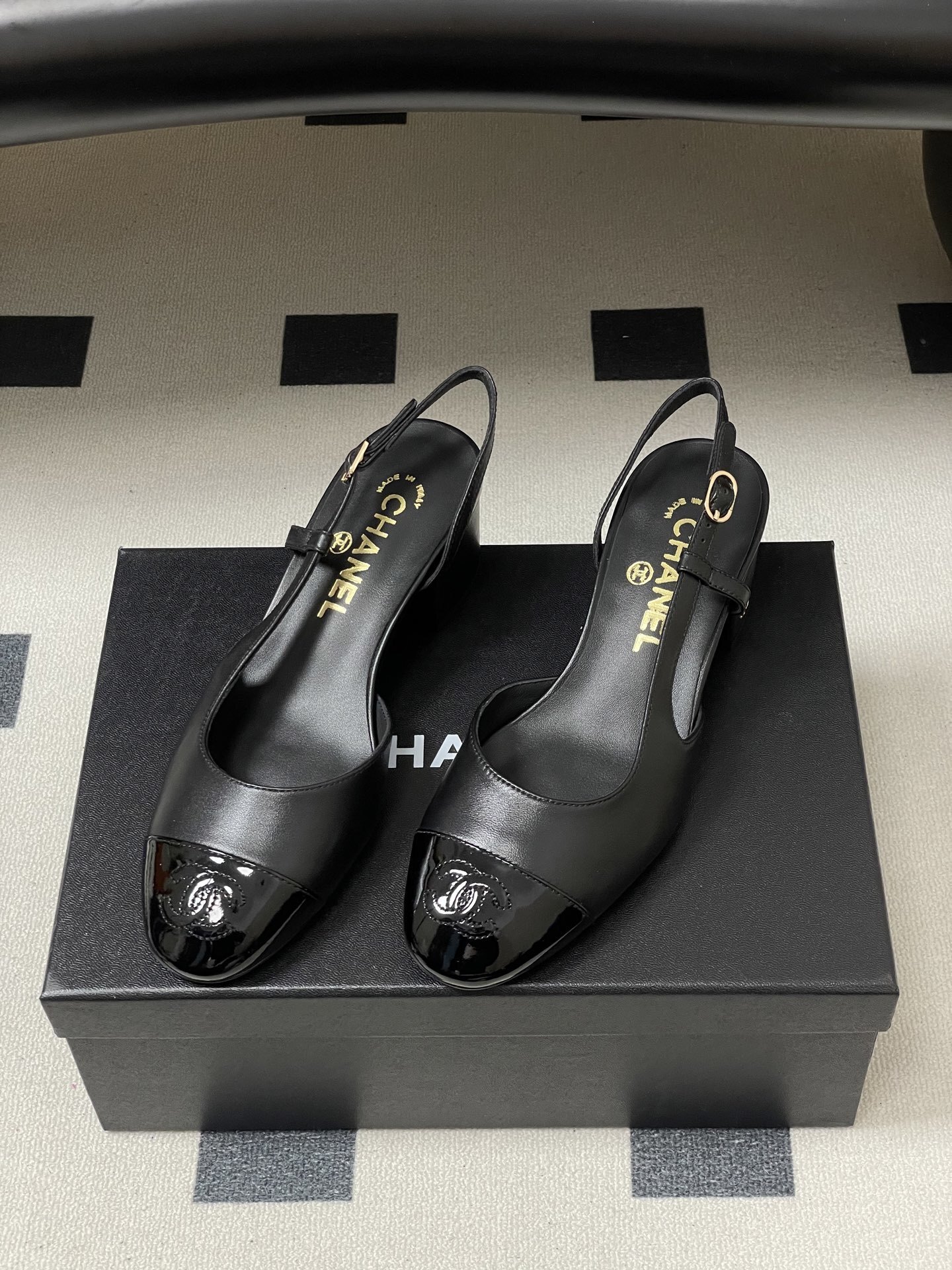 Pair of black Chanel slingback pumps with patent leather cap toe and gold CC logo on the block heel. - Hình 5